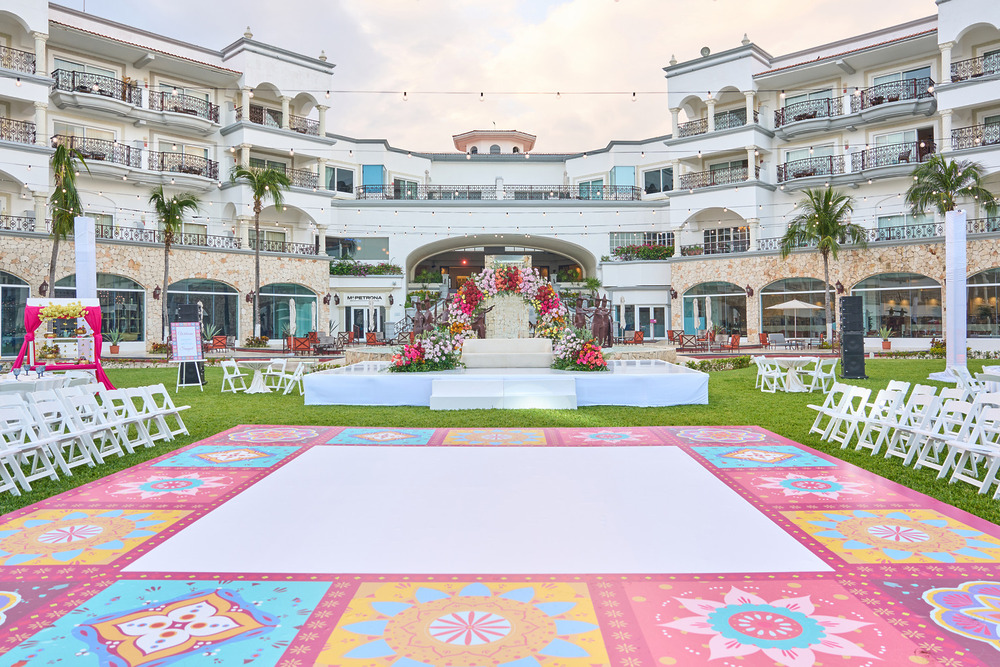 Destination wedding setup at a top luxury all-inclusive, featuring vibrant floors and lush floral decor.