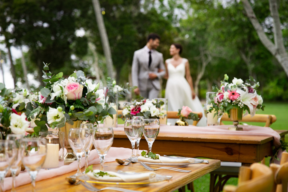Chic destination wedding table at top luxury all-inclusive; couple blurred in the background.