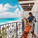 A woman relaxes in a hammock, reading a book at a luxurious destination wedding resort, while her partner gazes out over the ocean.