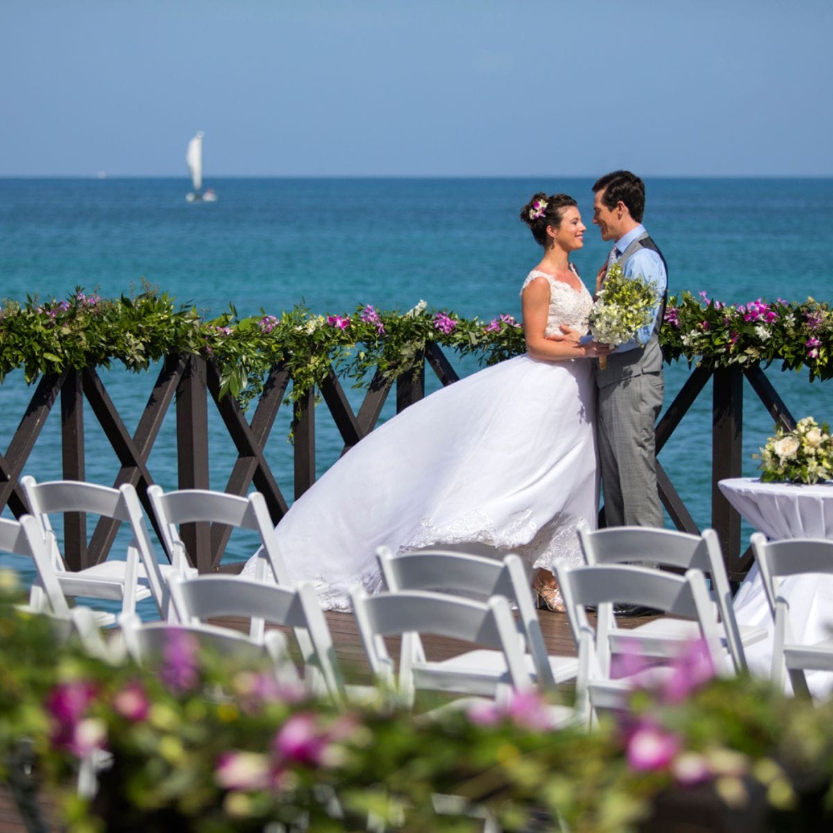 Bride and groom on a seaside deck, ideal for a destination wedding or large Jamaican weddings.