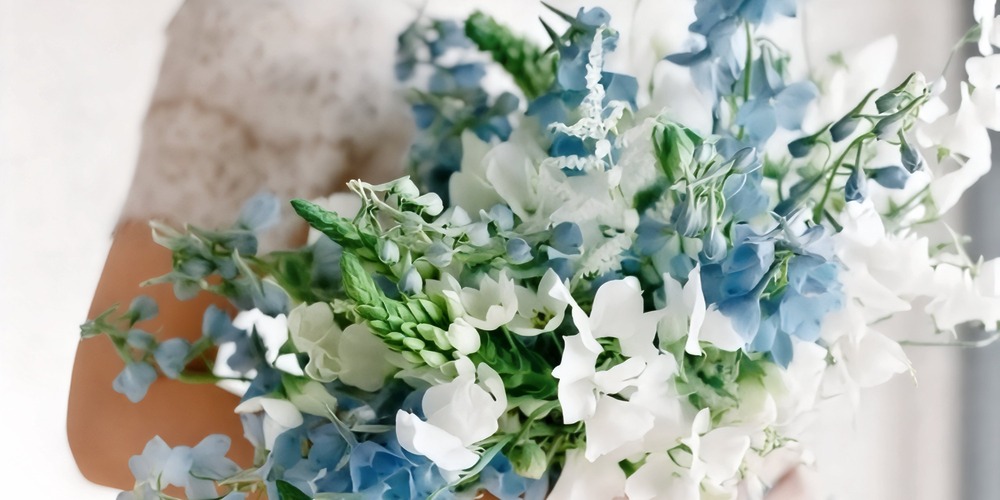 A stunning bouquet featuring blue, white, and green blooms—ideal for a spring wedding or as an elegant accessory for your destination wedding.