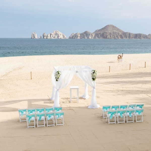 A chuppah is a canopy under which a couple stands for the duration of their ceremony on a Cabo San Lucas beach wedding at Riu Palace CSL