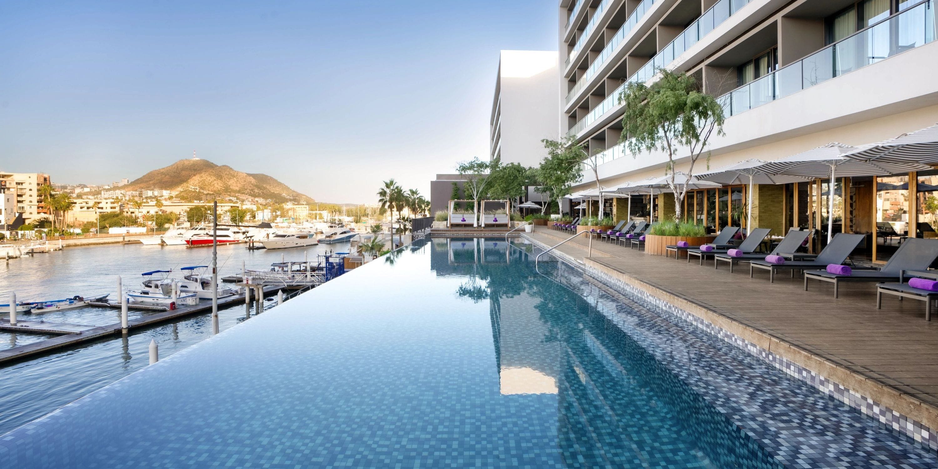 Infinity pool at Breathless Cabo, perfect for a destination wedding, overlooks marina and mountains.