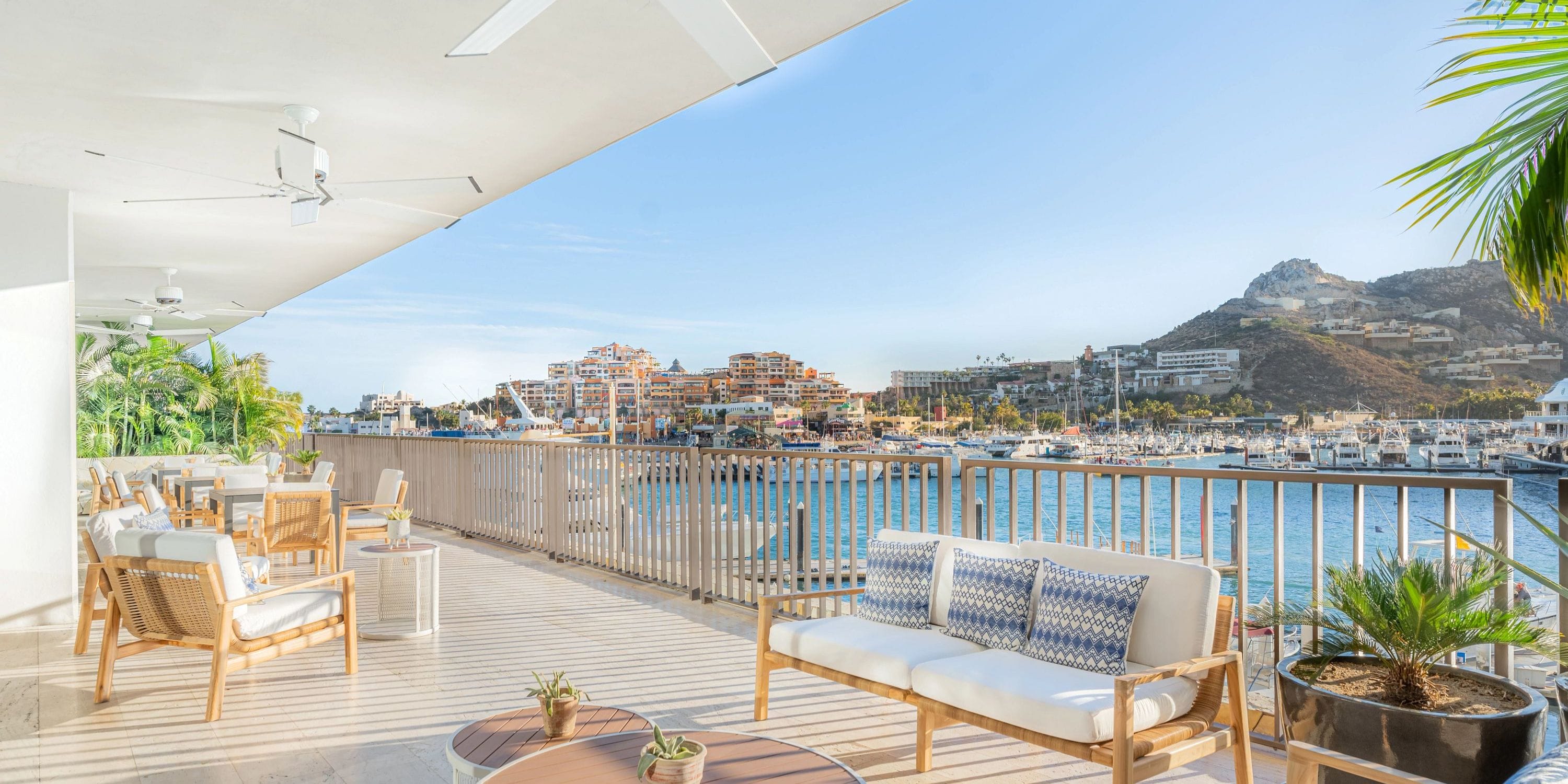 Chic lounge at Breathless Cabo, perfect for a destination wedding, overlooks marina and hills.