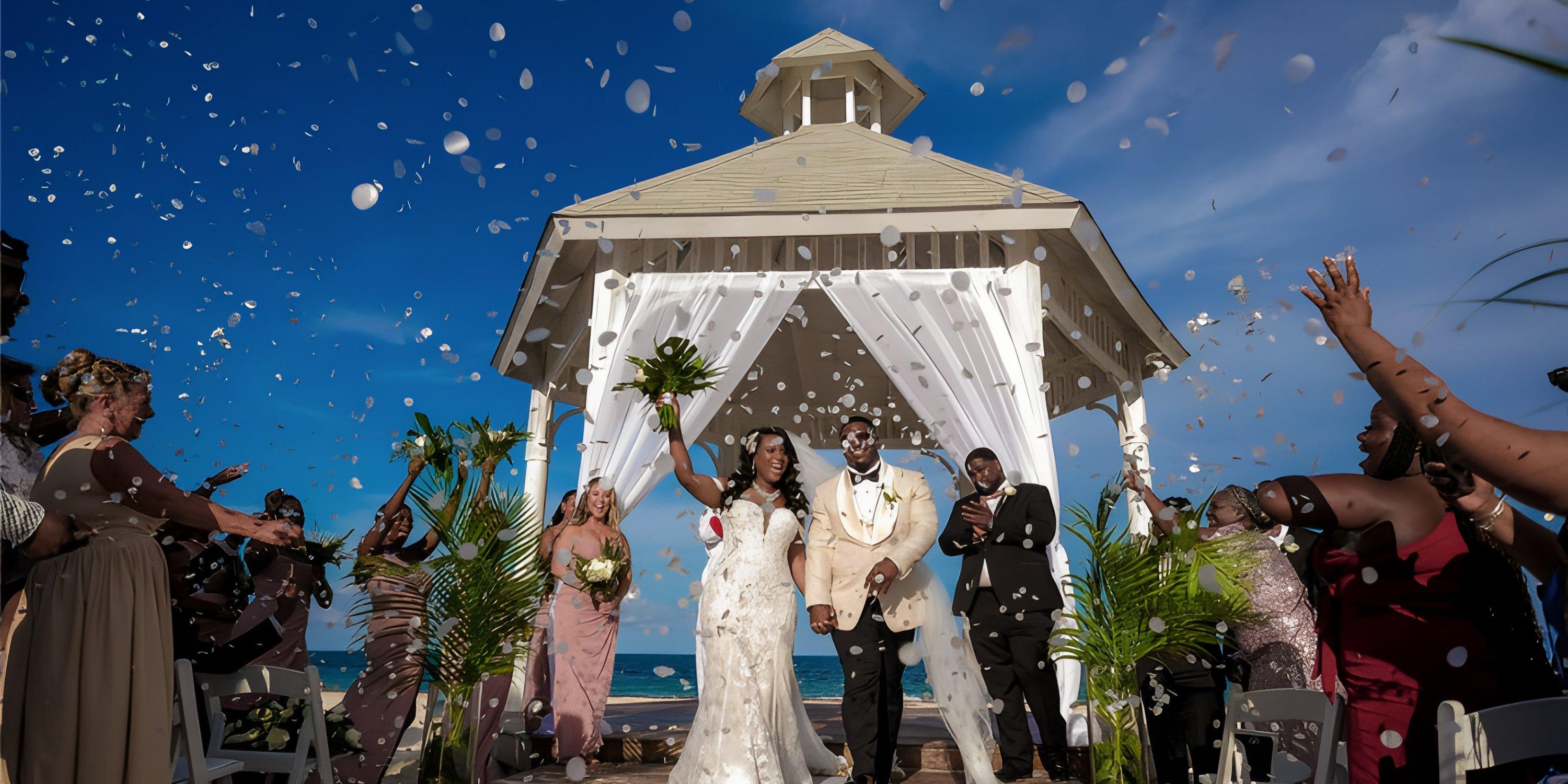 At their destination wedding, newlyweds walk the aisle at Majestic Elegance Costa Mujeres as petals fly.