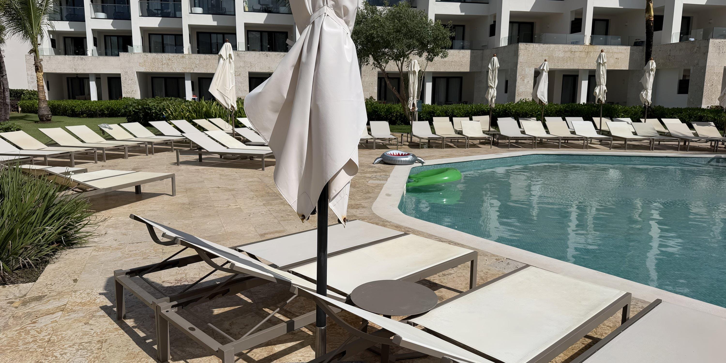 Empty lounge chairs and closed umbrellas by the pool at Dreams Macao Beach resort, a destination wedding spot.