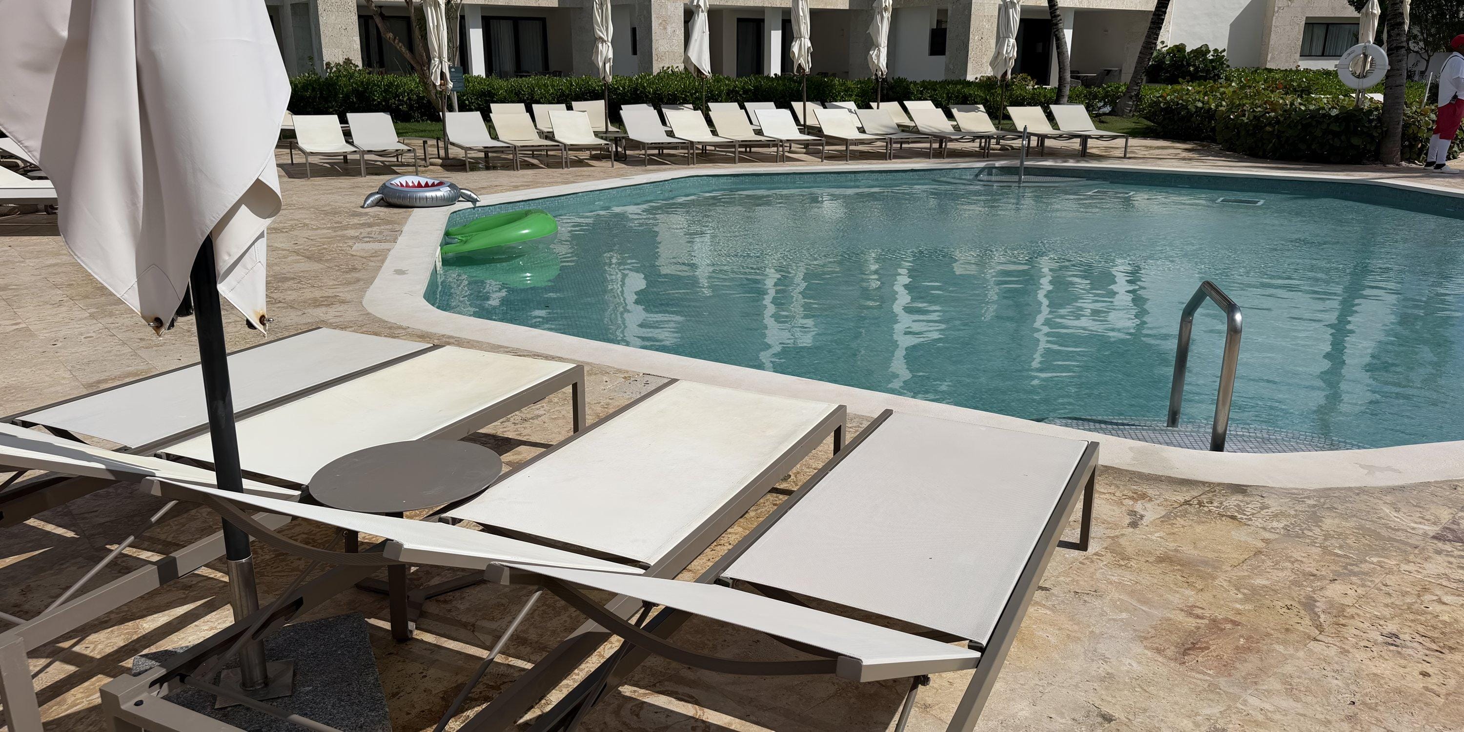 Dreams Macao Beach pool, perfect for a destination wedding, with empty lounge chairs and green float.