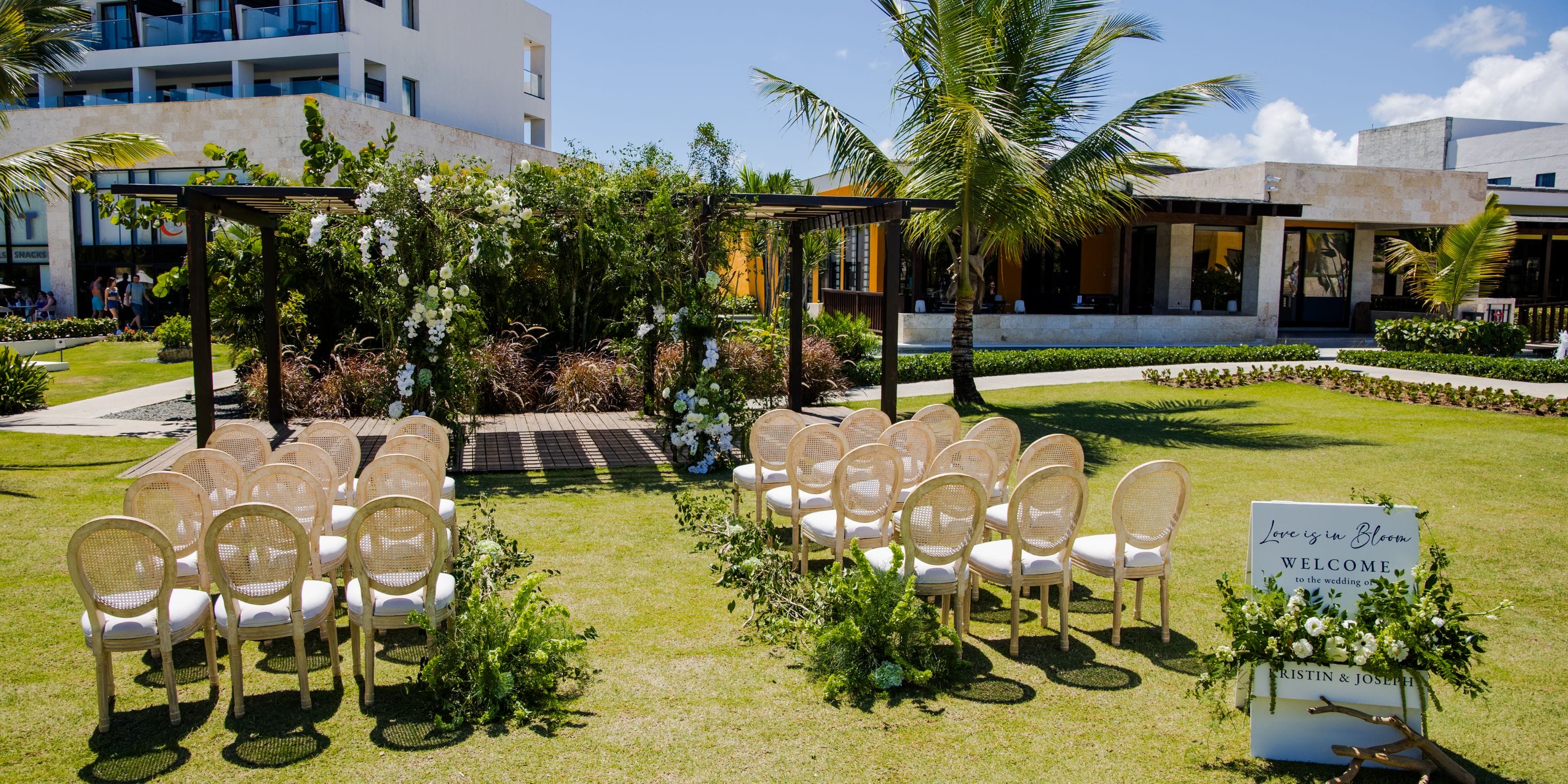 Destination wedding ceremony at Dreams Macao Beach with arranged chairs, floral decor, and welcome sign.