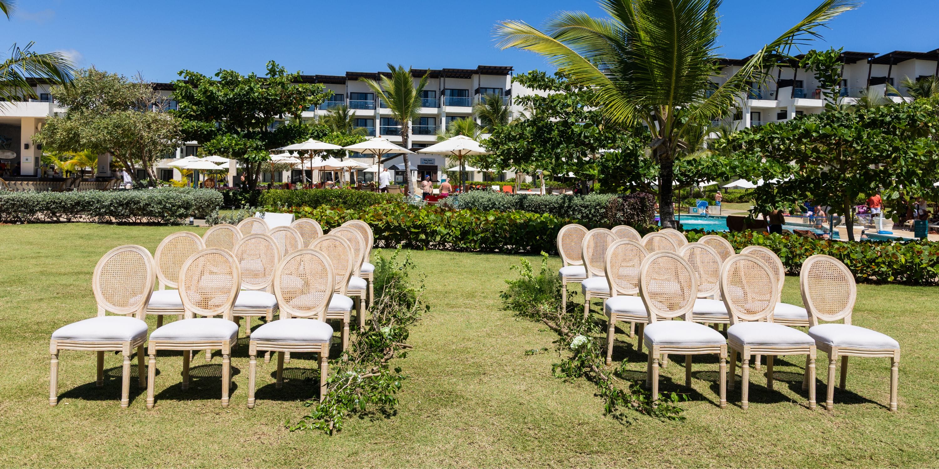 White chairs arranged on grass at Dreams Macao Beach, prepared for a stunning destination wedding ceremony.