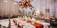 Dreams Riviera Cancun destination wedding banquet hall with elegant tables, floral centerpieces, and drapes.