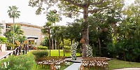 Destination wedding at Dreams Riviera Cancun with wooden chairs, floral arch, and striking tree centerpiece.