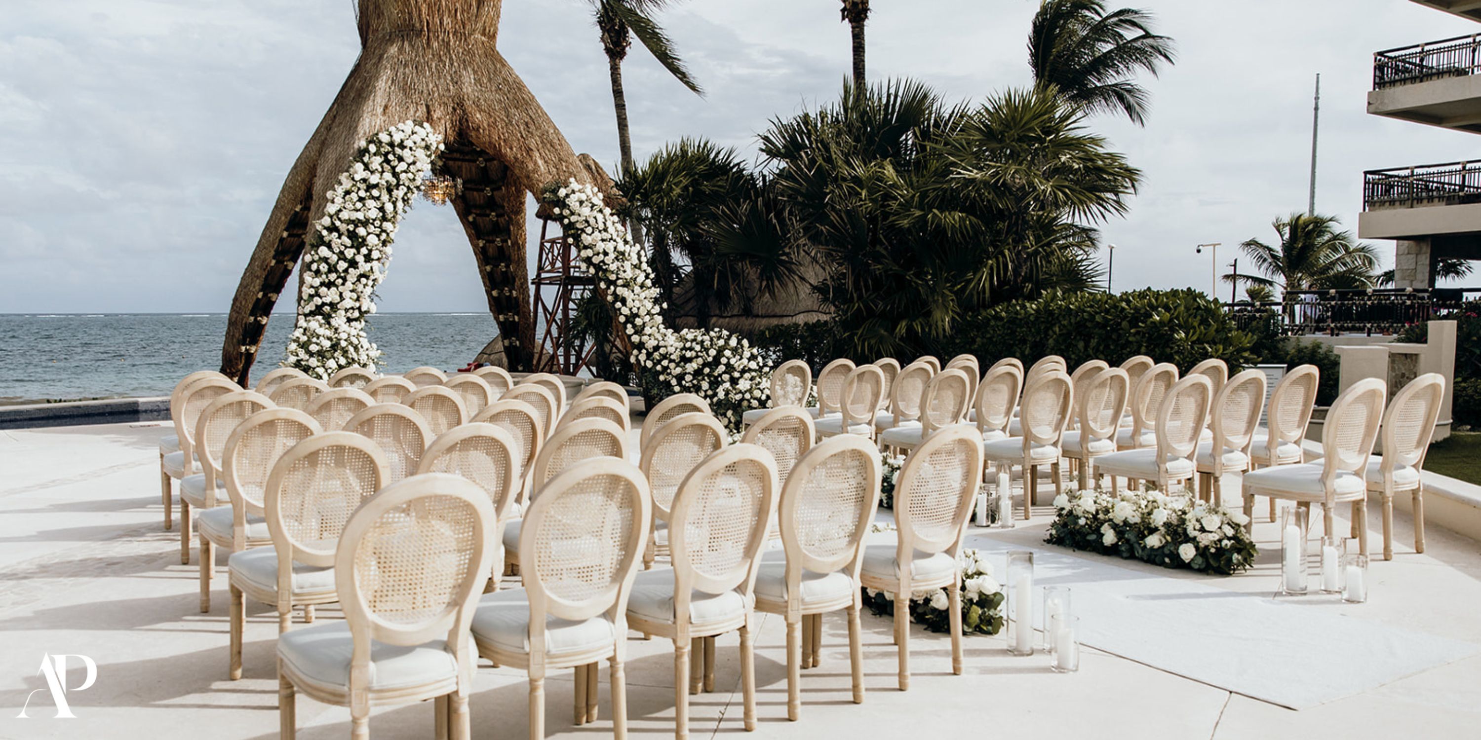 Chairs set up for a destination wedding by the ocean at Dreams Riviera Cancun, adorned with flowers.