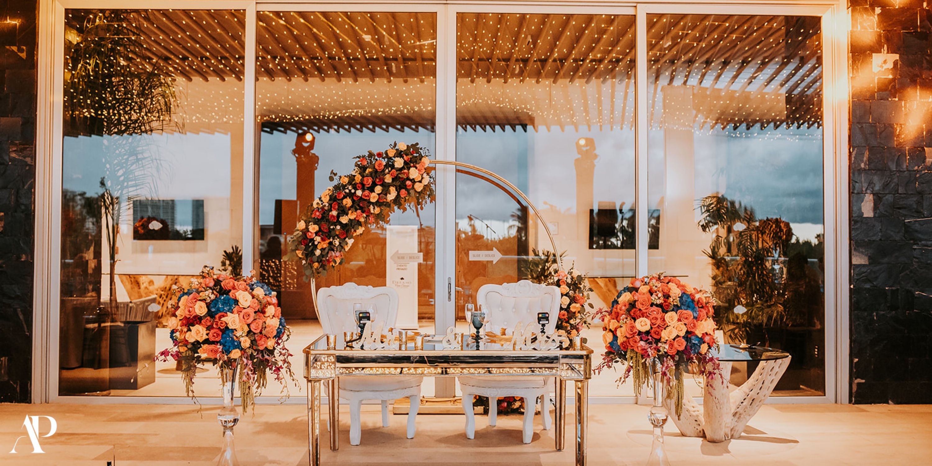 Chic destination wedding sweetheart table at Dreams Vista Cancun, adorned with florals and a decorative arch.