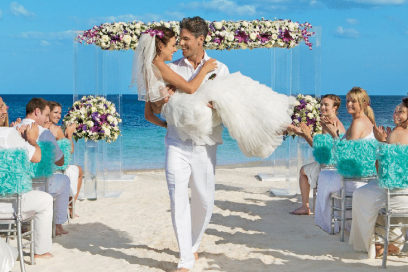 A bride and groom walking down the aisle at a Dreams Tulum destination wedding on the beach.
