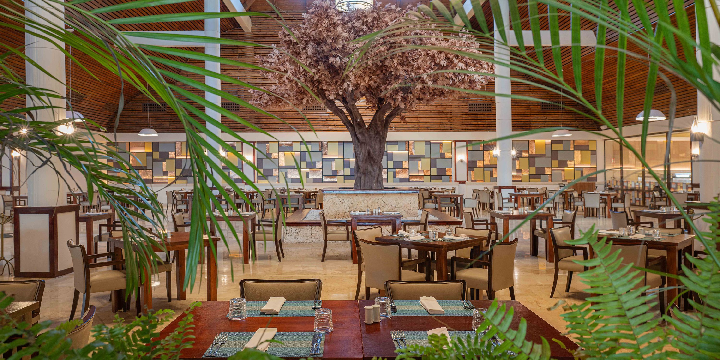 Grand Palladium Bavaro offers ample seating, a faux tree, and lush plants&mdash;ideal for a destination wedding.