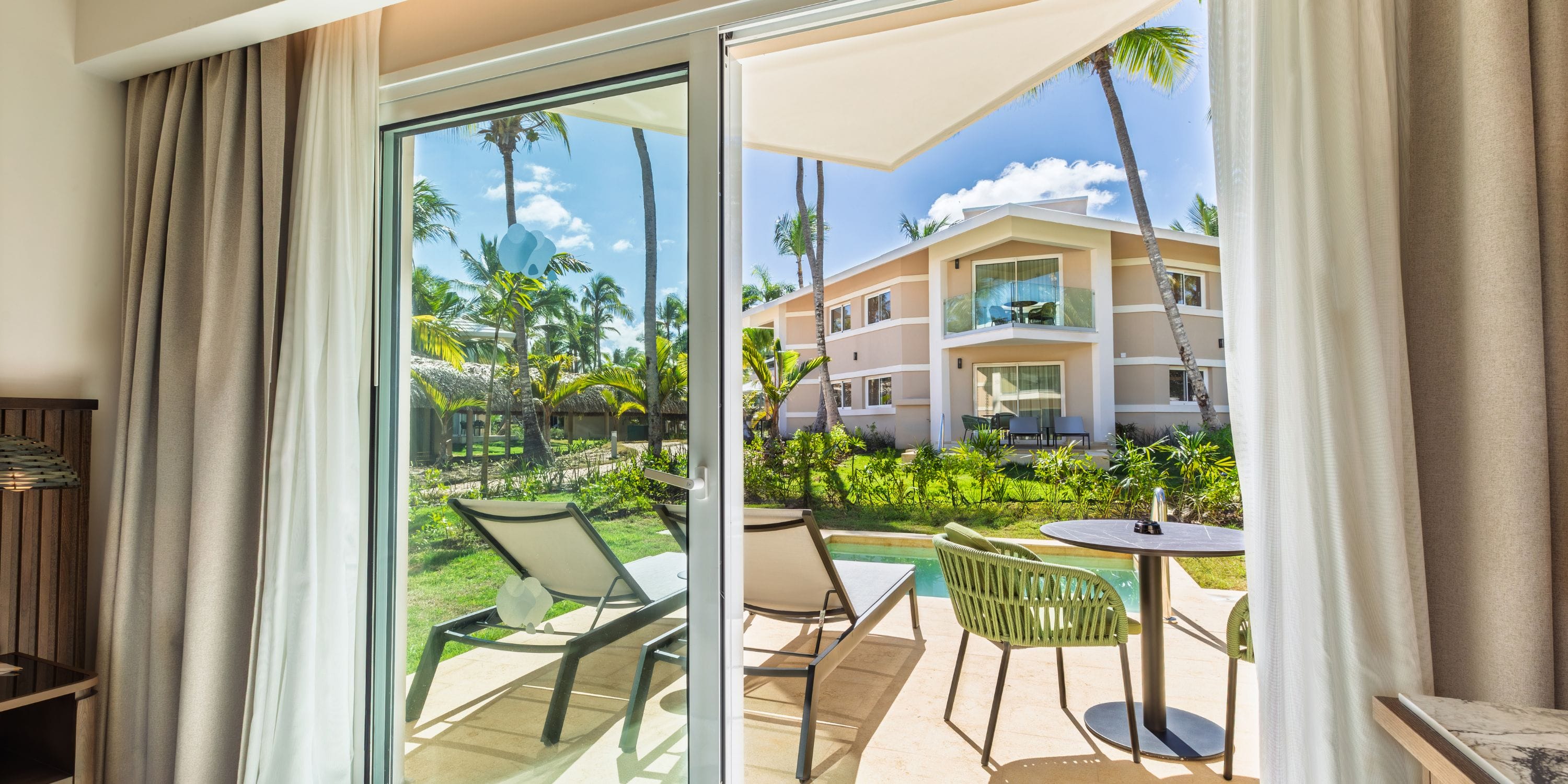 Patio view of pool, lounge chairs, and garden at Grand Palladium Bavaro&mdash;ideal for a destination wedding.