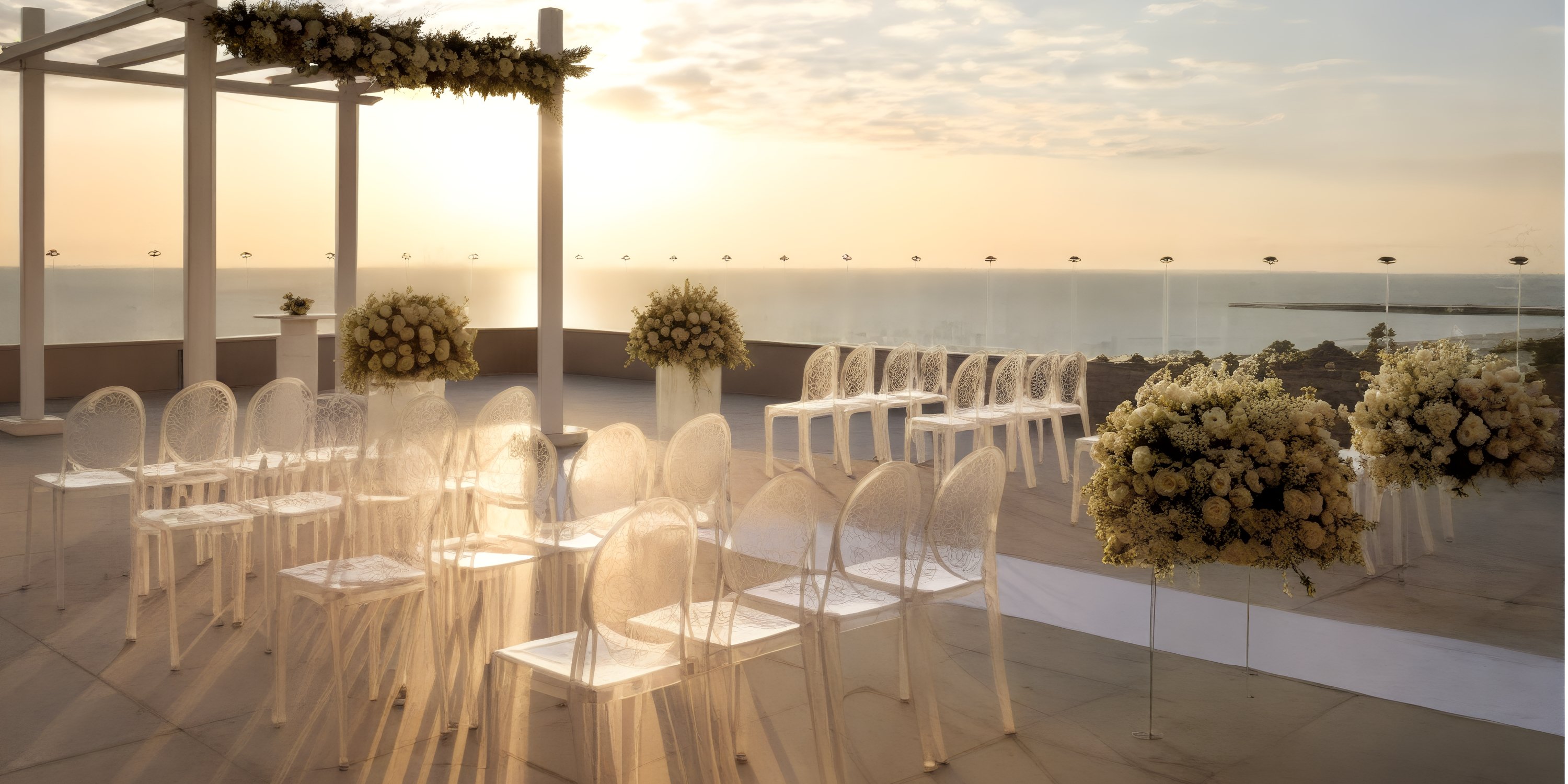 Destination wedding at Grand Palladium Costa Mujeres with clear chairs, white florals, and ocean sunset views.