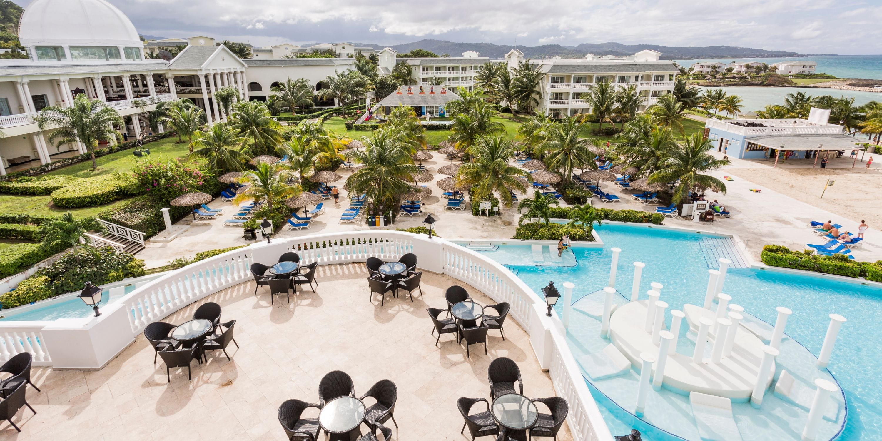 Grand Palladium Jamaica: pool, palm trees & ocean view—perfect for a romantic destination wedding.
