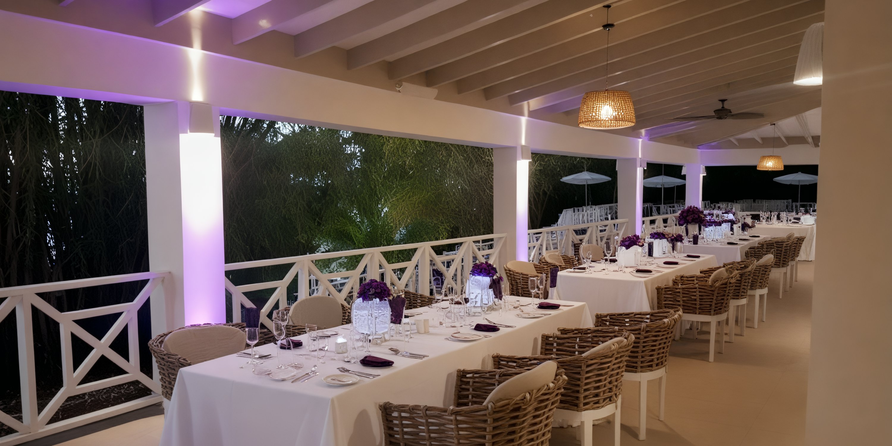 Chic destination wedding setup at Grand Palladium Jamaica with white tables and purple floral decor.