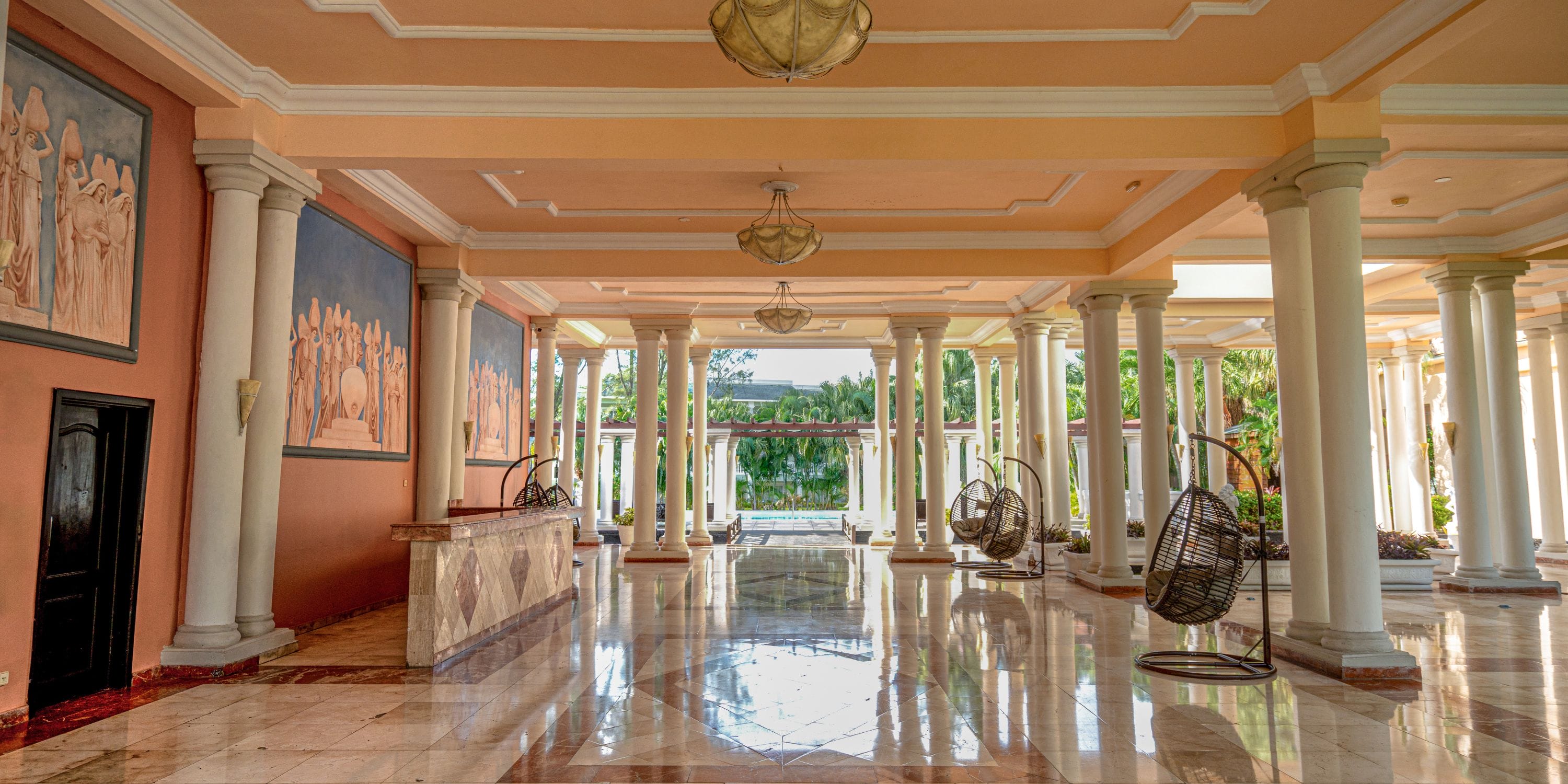 Grand Palladium Jamaica: lobby with columns, murals, and greenery—perfect for a destination wedding.