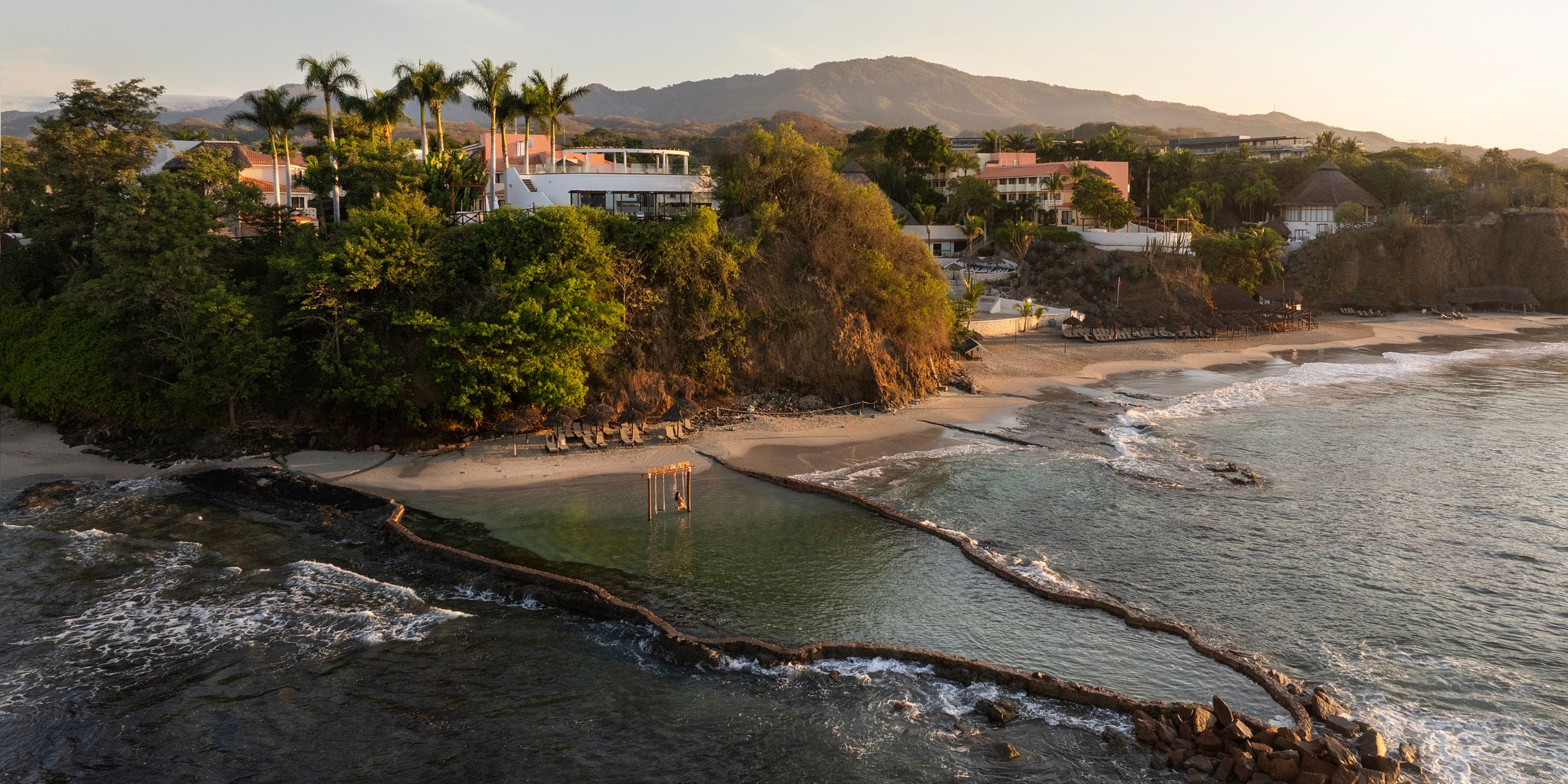 Grand Palladium Vallarta: ideal for weddings with beachfront houses, palms, and a tidal pool.