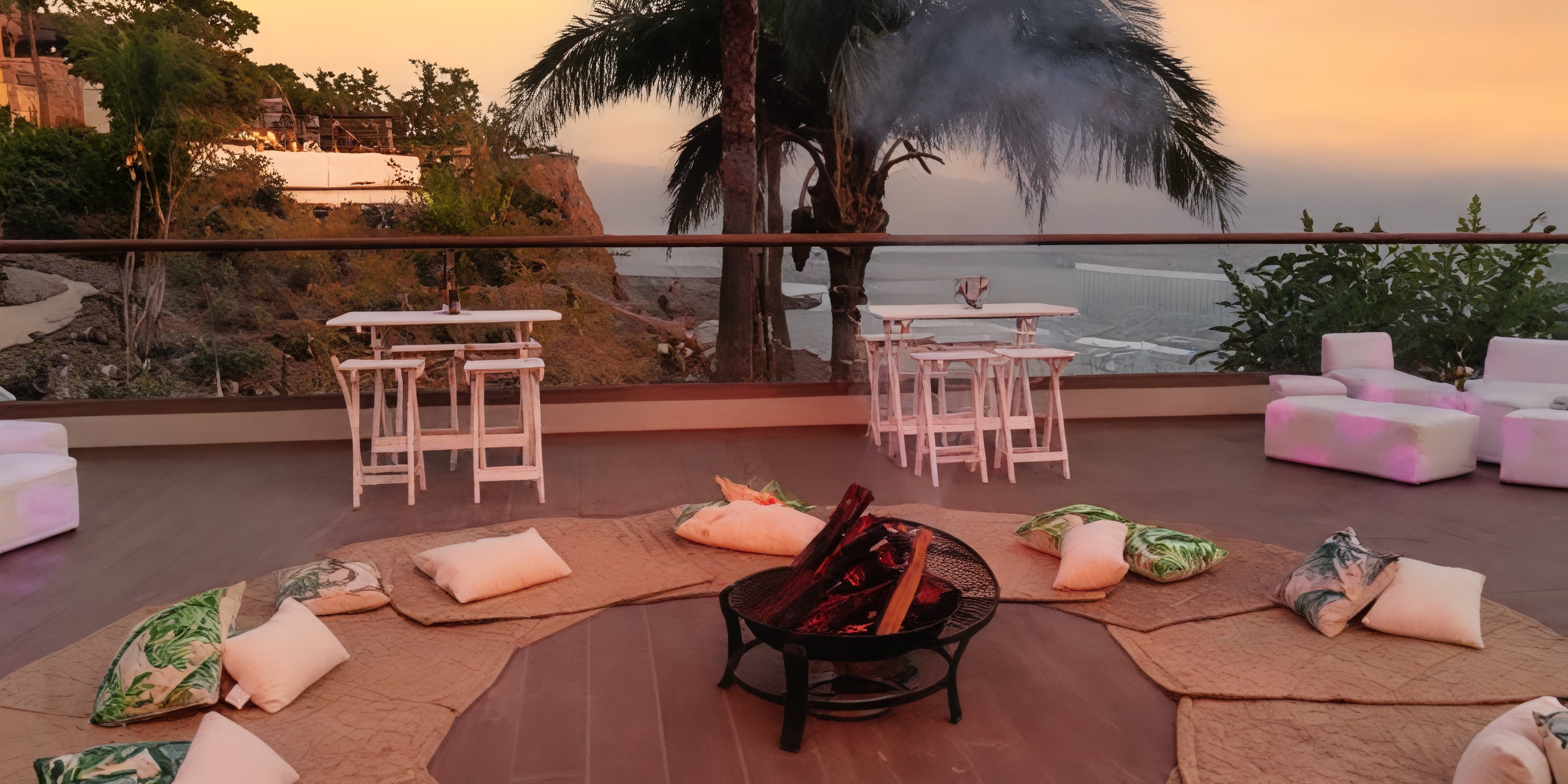 Grand Palladium Vallarta terrace set for a destination wedding: fire pit, cushions, tables, sunset ocean views.