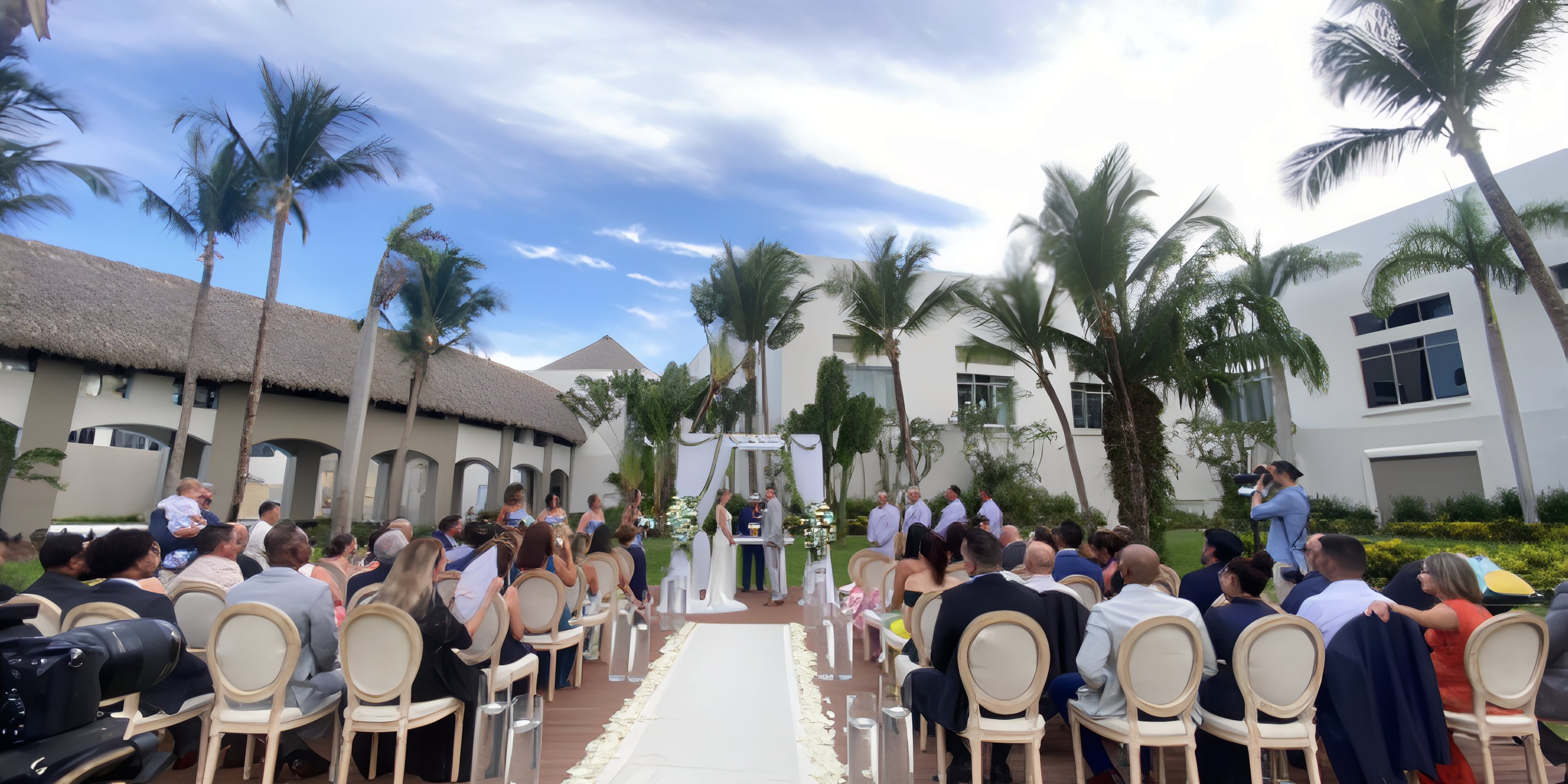 Destination wedding at Hard Rock Punta Cana with guests seated, viewing the couple and officiant outdoors.