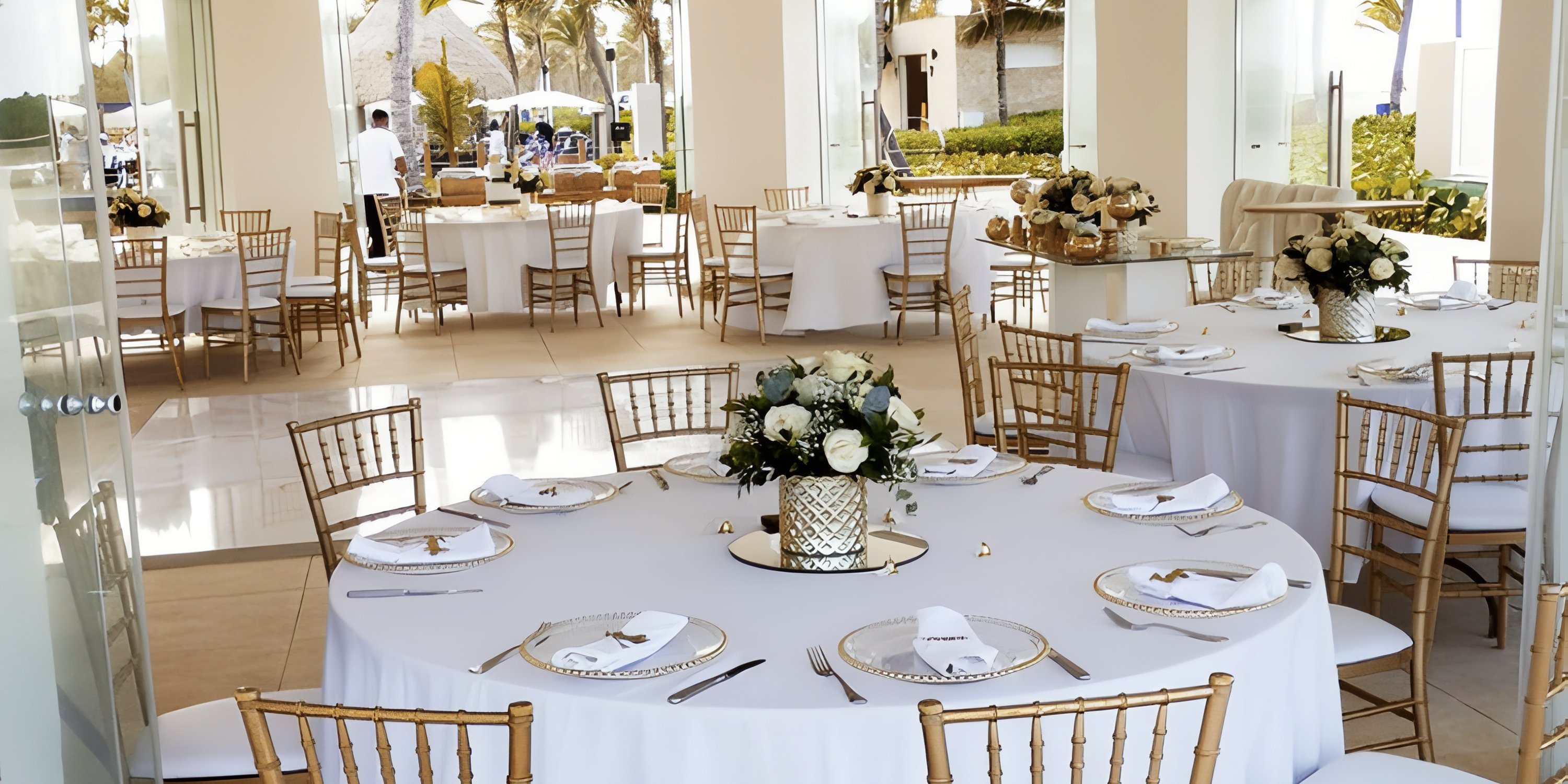 Banquet hall at Hard Rock Punta Cana set for a destination wedding with round tables and floral centerpieces.