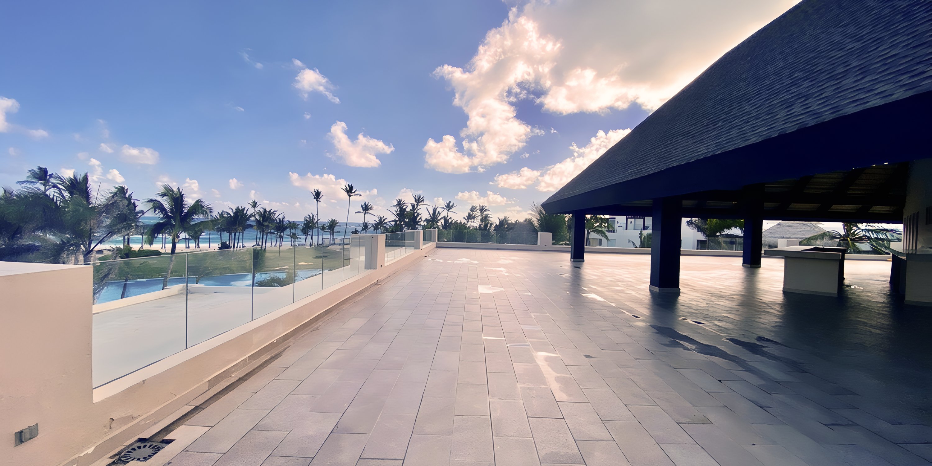 Outdoor terrace at Hard Rock Punta Cana, ideal for a destination wedding, with tiles, palms, and sea view.