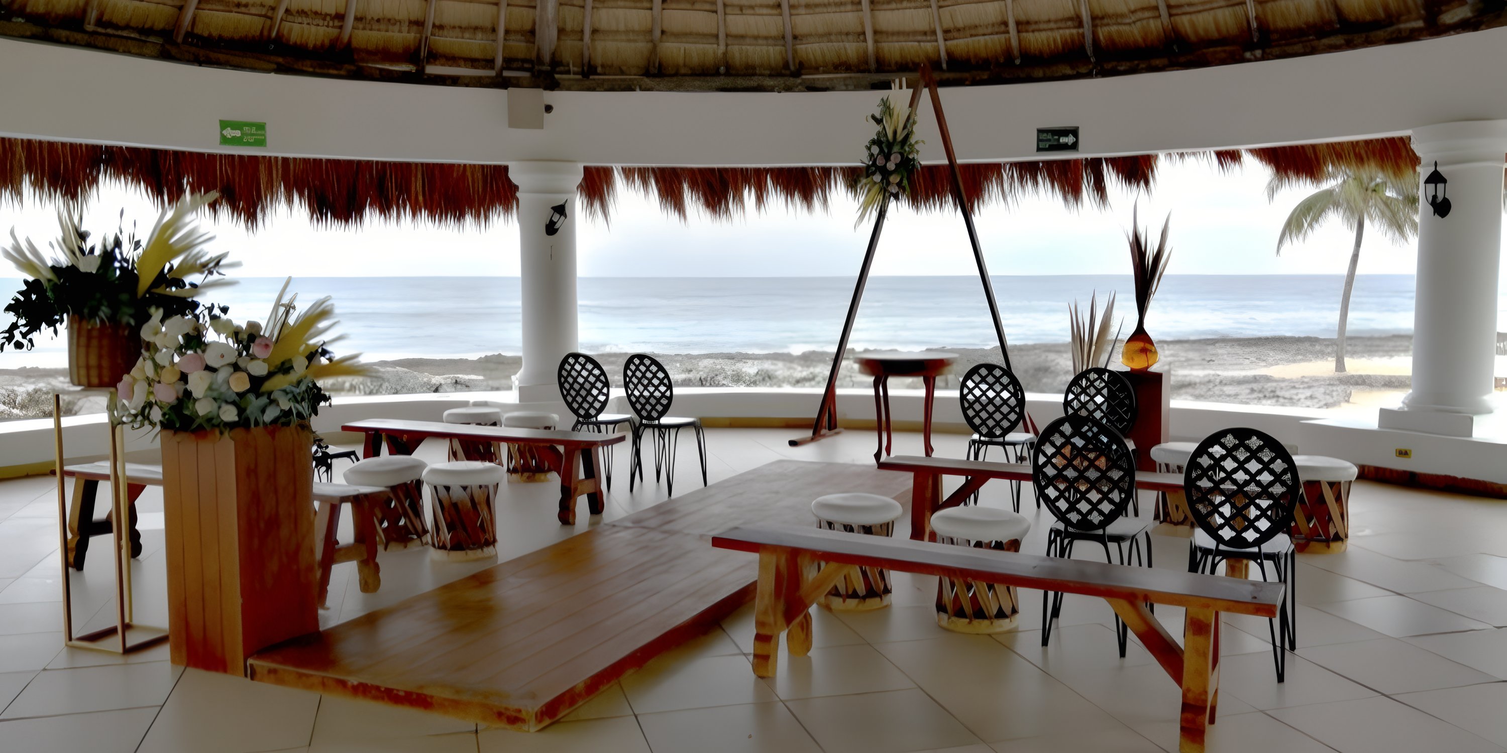 Ocean-view open-air wedding venue at Hard Rock Riviera Maya, nestled under a thatched roof.