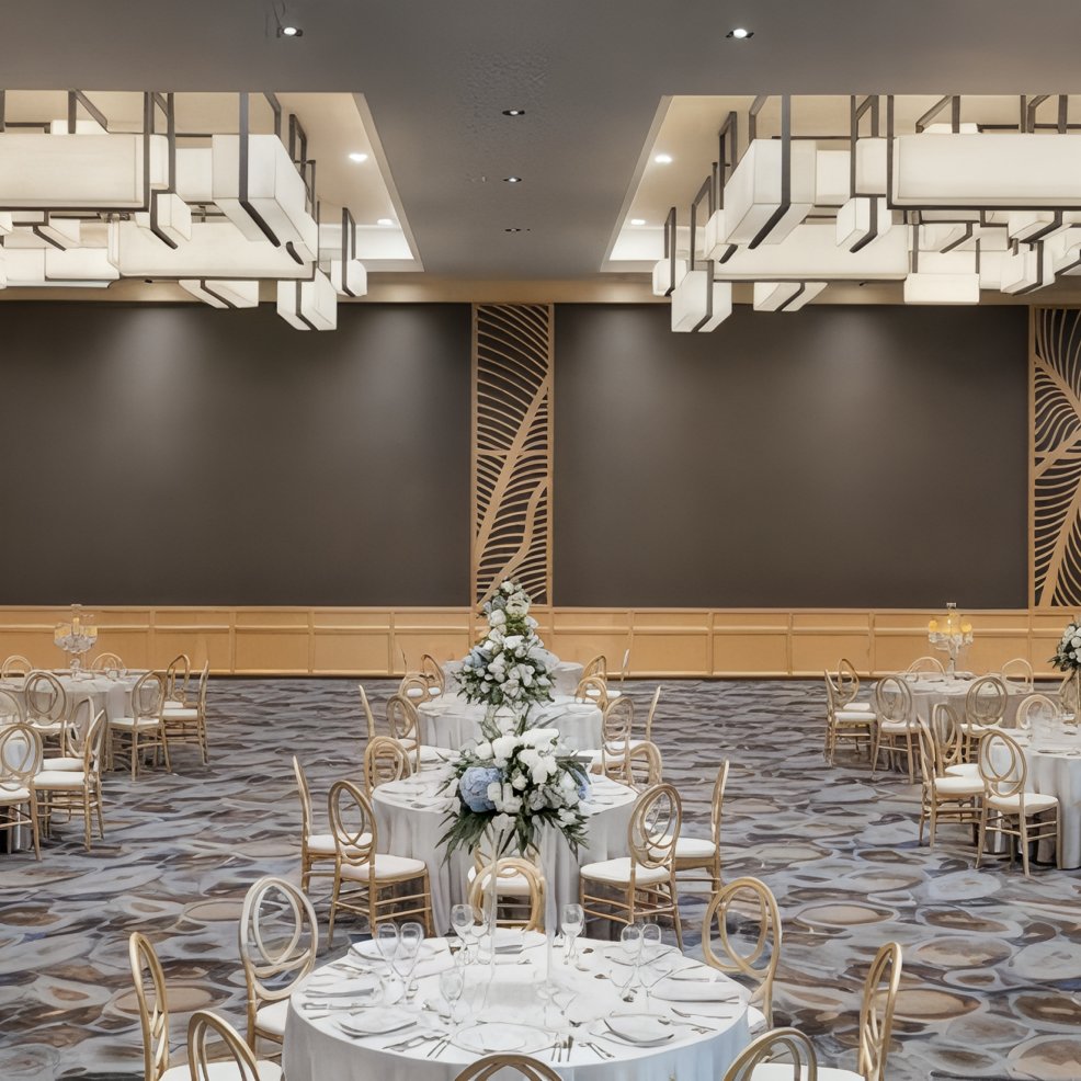 Elegant banquet hall set for a destination wedding, with round tables, floral centerpieces, and chic lighting.