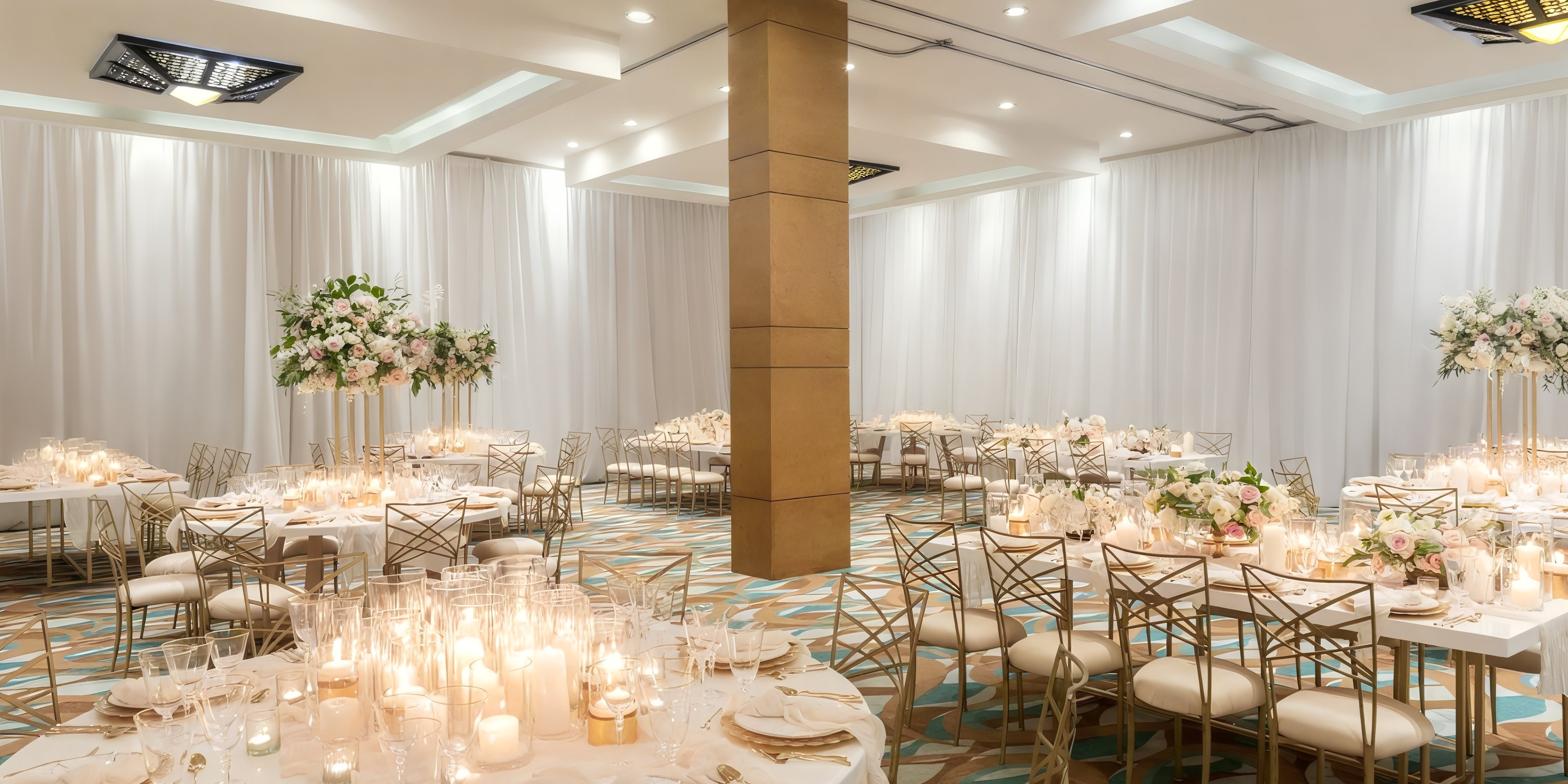 Elegant wedding banquet hall at Hyatt Ziva Los Cabos with round tables, gold chairs, and candlelight.