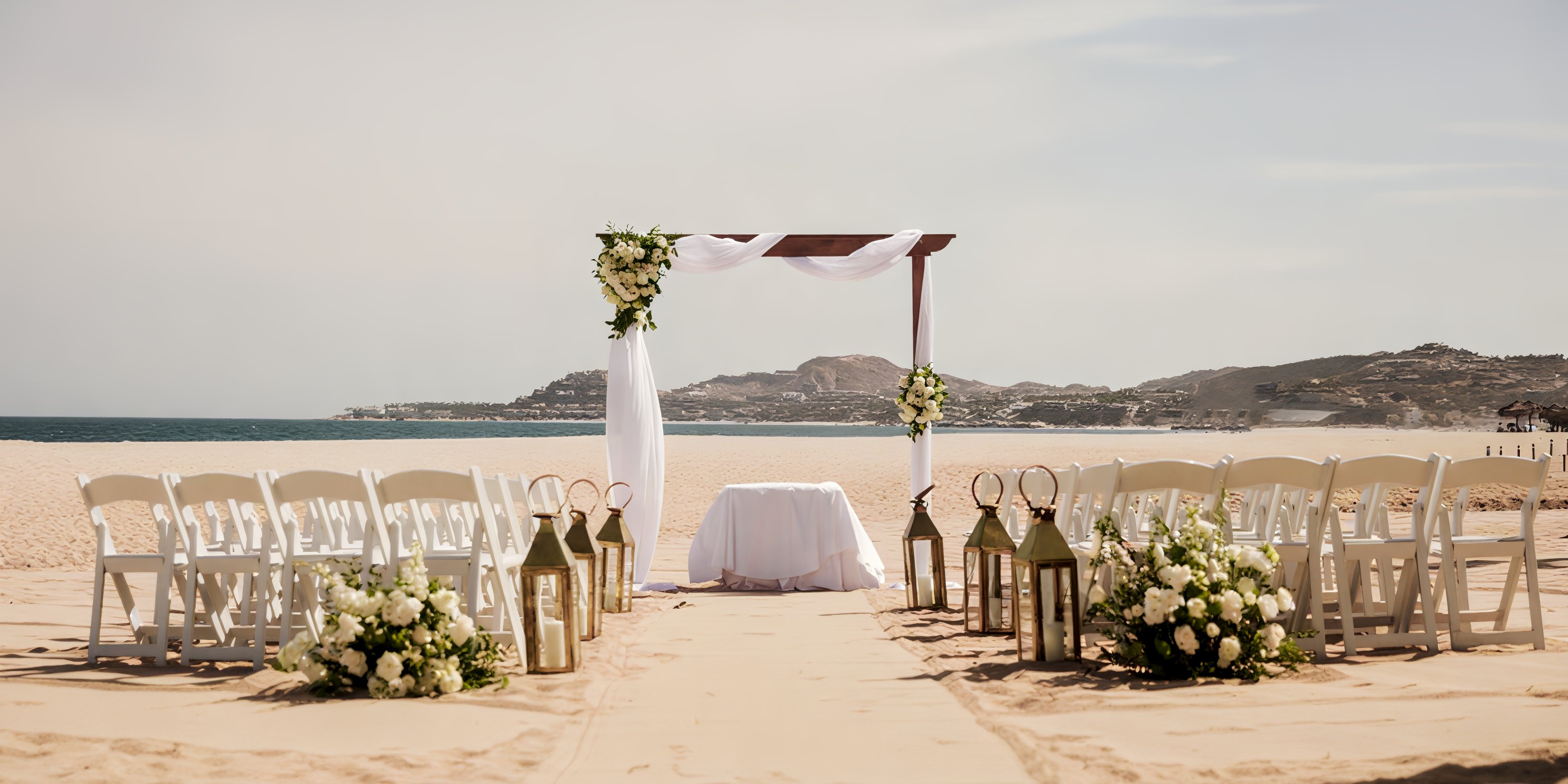 Destination wedding at Hyatt Ziva Los Cabos with white chairs, floral arch, and oceanfront ceremony setup.