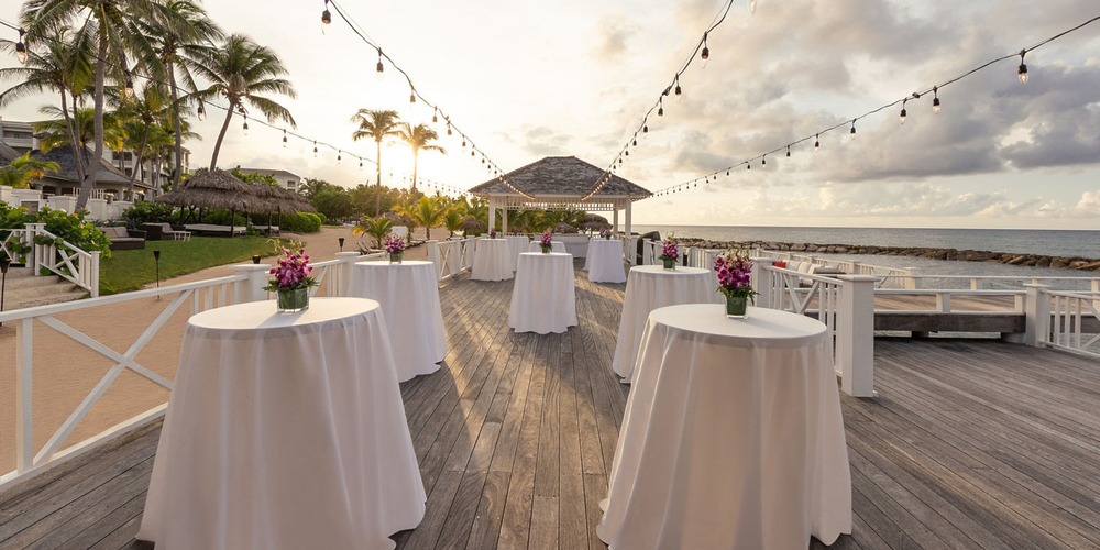 Host your dream destination wedding at Hyatt Zilara Rose Hall, where cocktail tables are elegantly arranged along the beachfront, offering breathtaking sunset views.