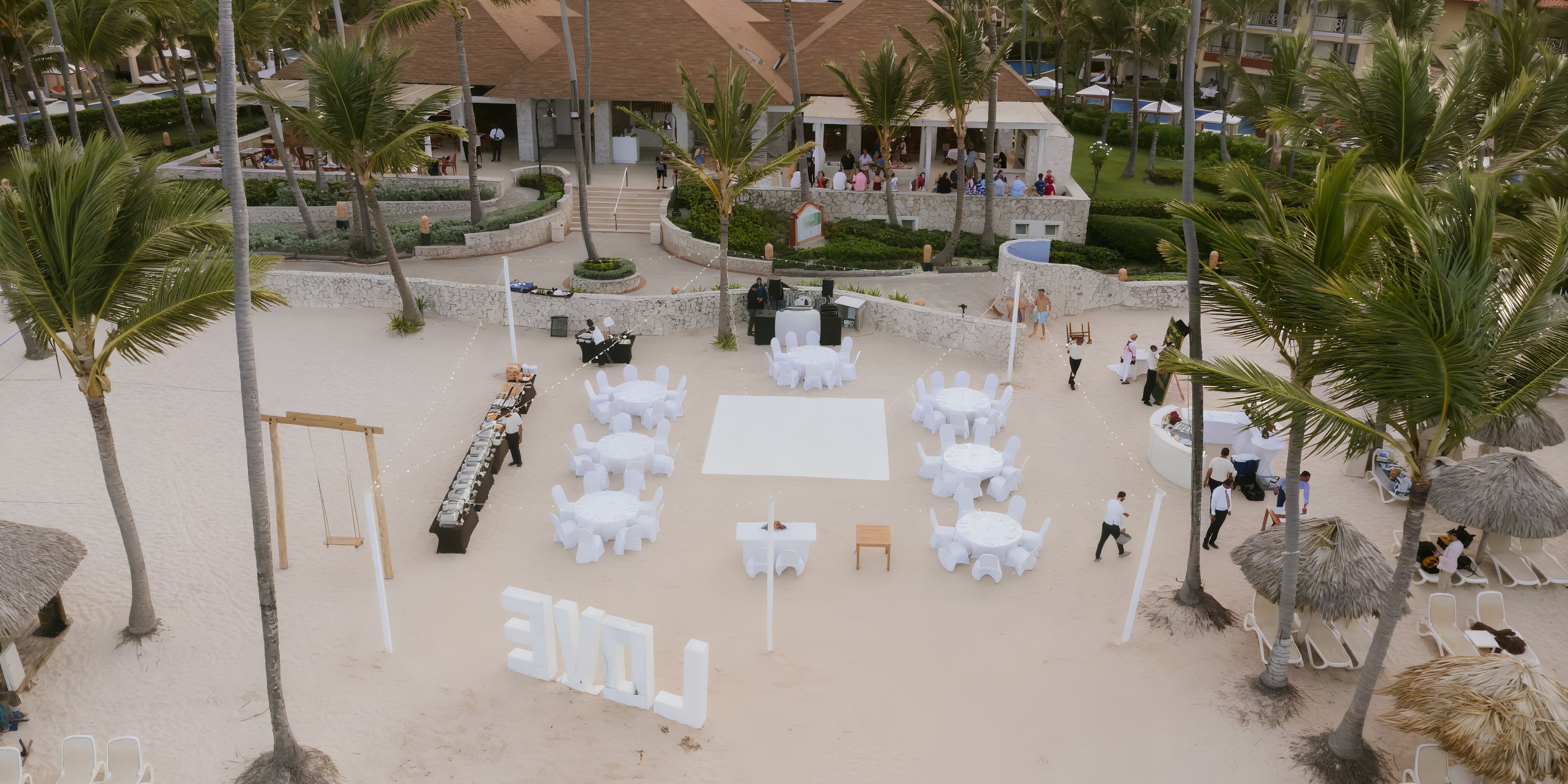 Majestic Elegance Punta Cana: dreamy destination wedding setup with round tables, palms, and "LOVE" letters.