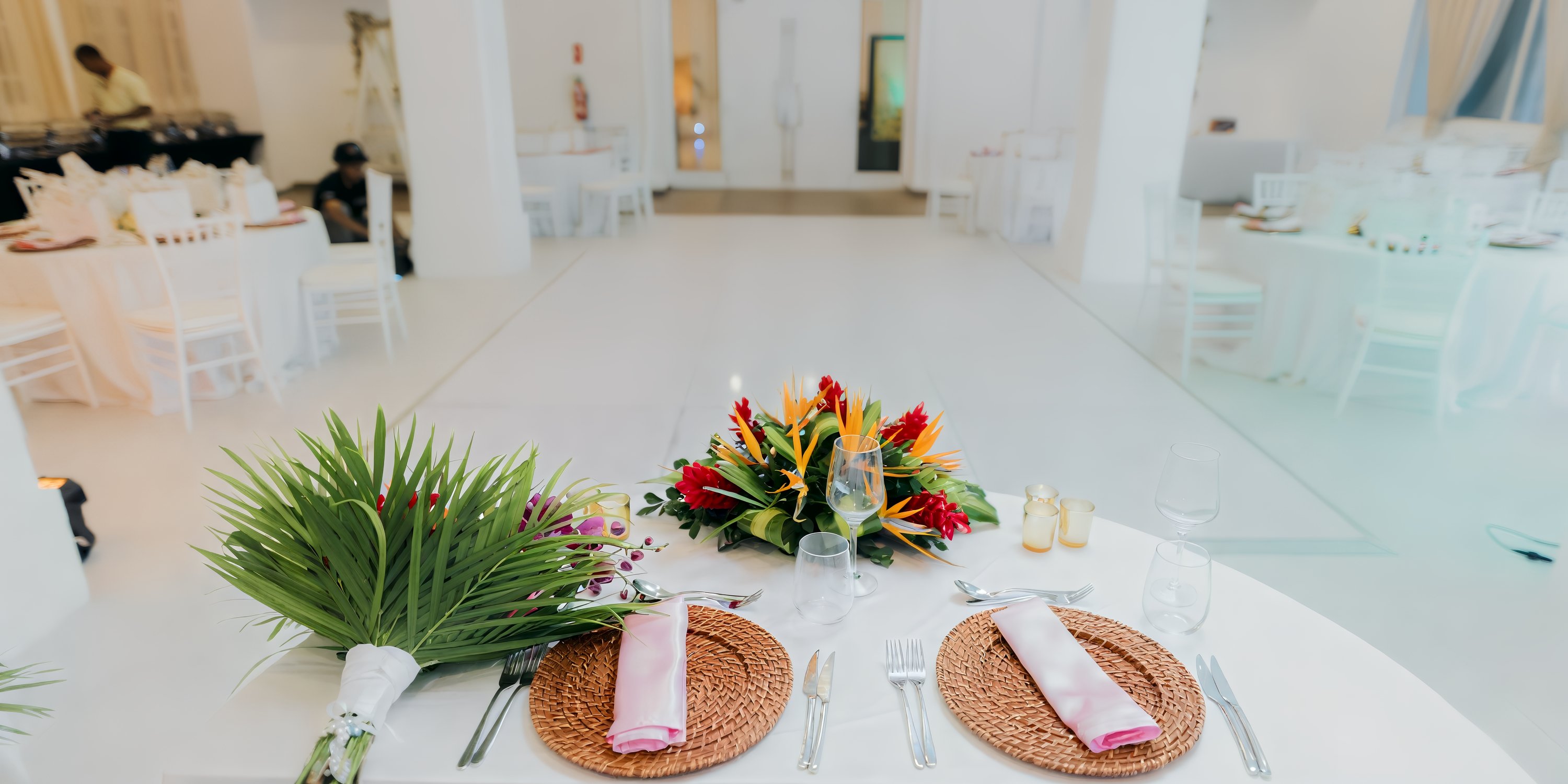 A romantic wedding table for two beneath tropical flowers in Majestic Elegance Punta Cana’s white hall.