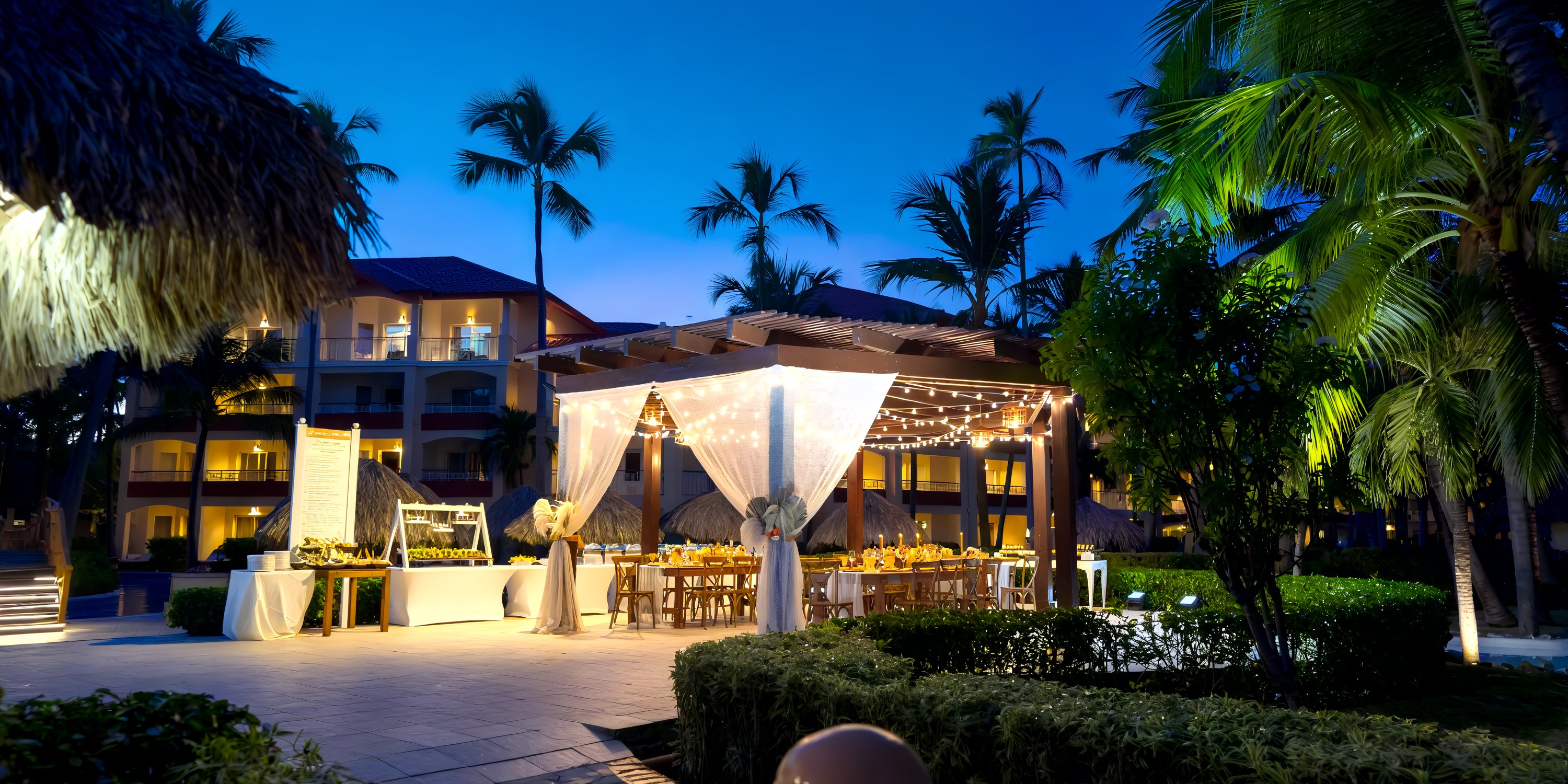 Destination wedding evening at Majestic Elegance Punta Cana under canopy lights and swaying palm trees.