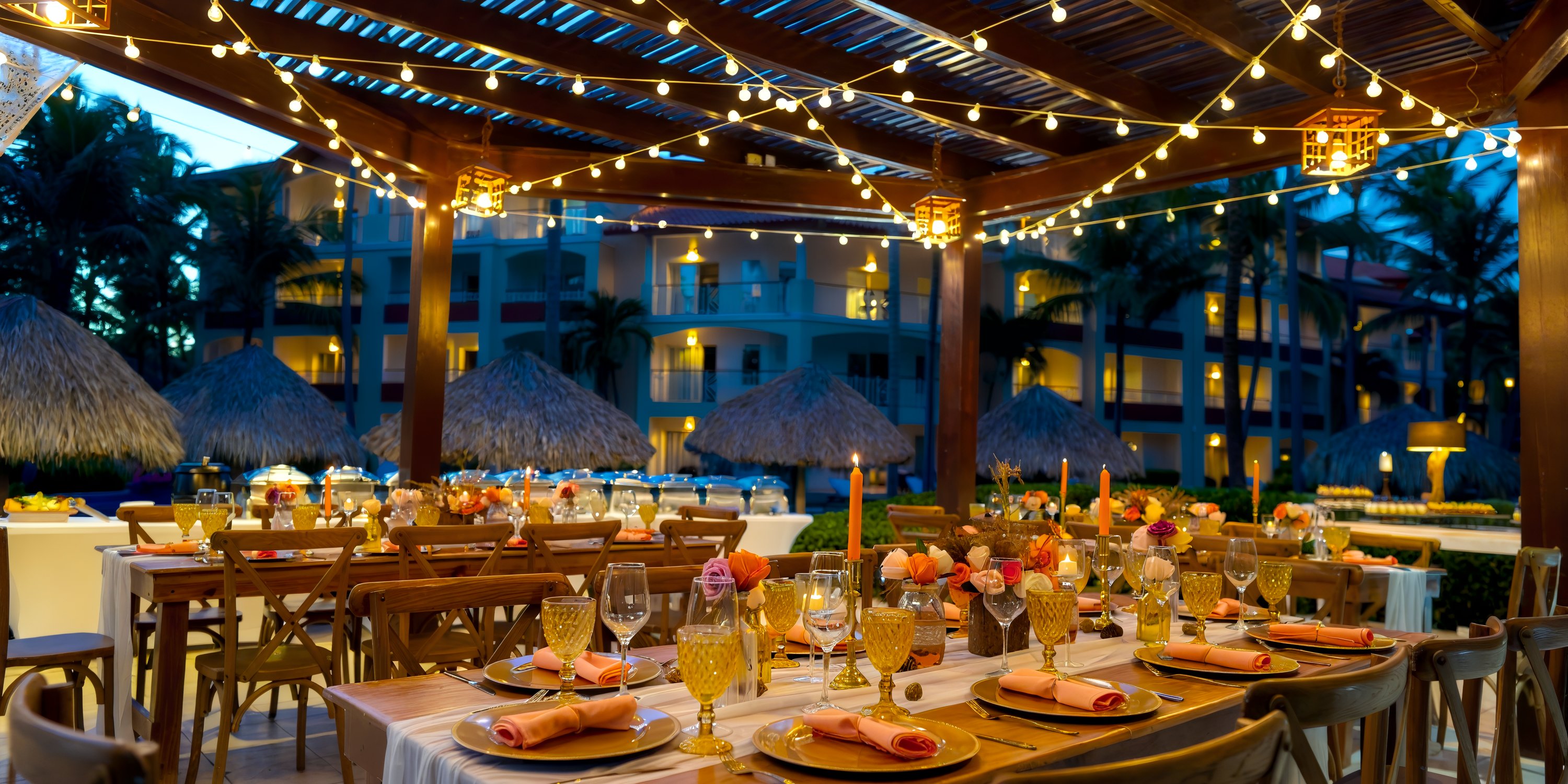 Enjoy a romantic destination wedding dinner outdoors at dusk, beneath string lights and a wooden pergola.