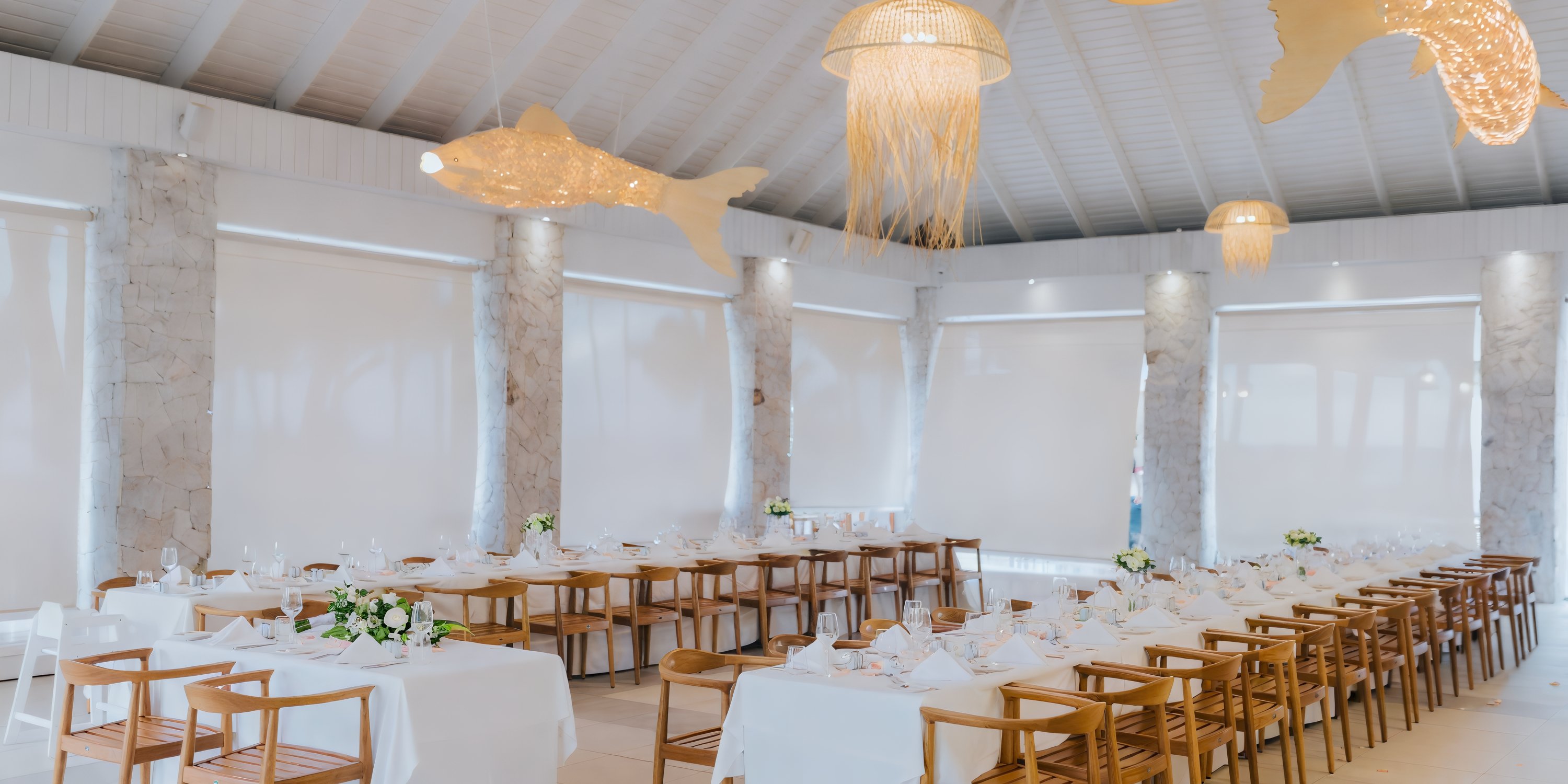 Long tables prepared for a destination wedding at Majestic Elegance Punta Cana, with fish-shaped lights.