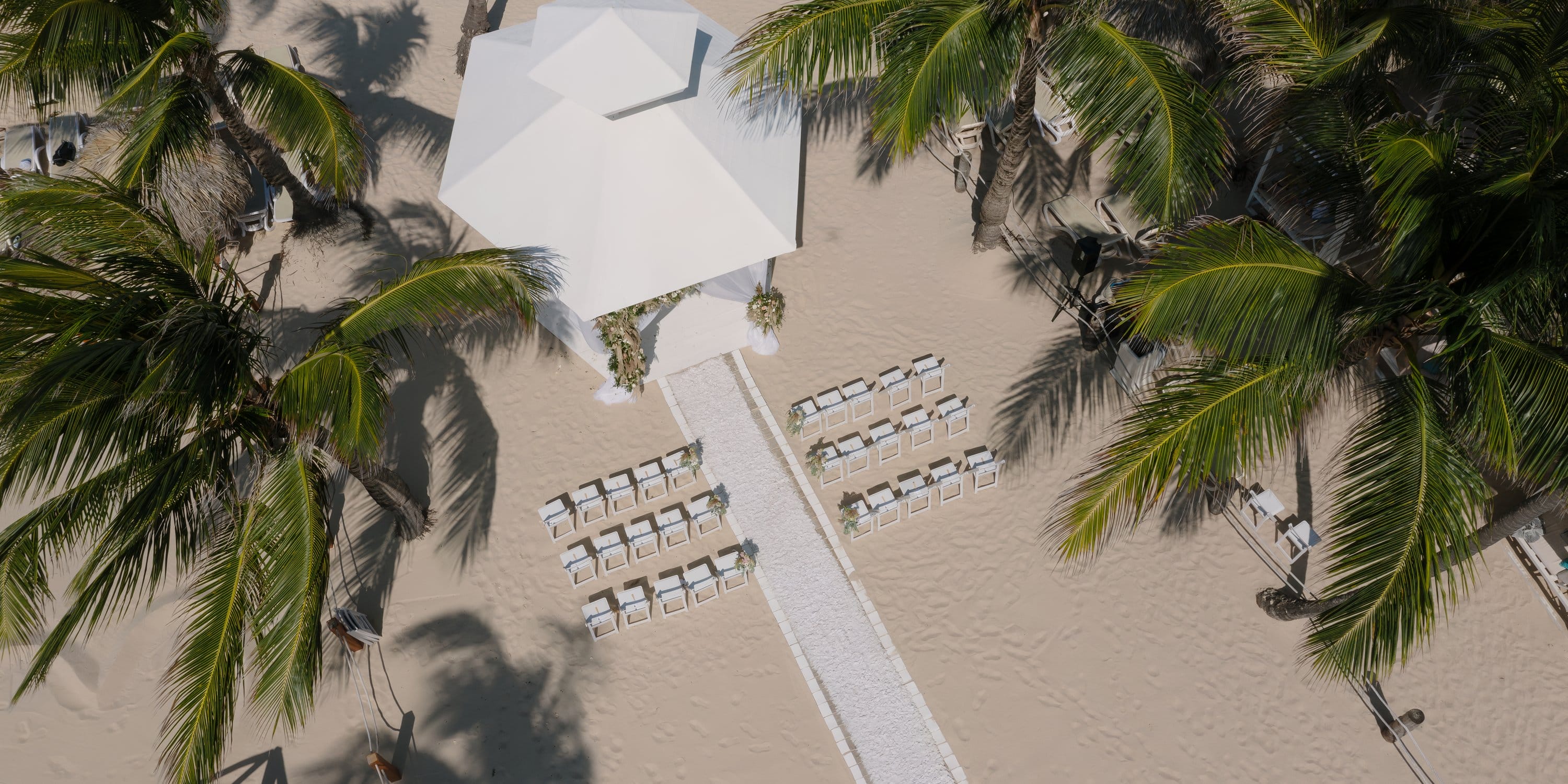 Aerial shot of a destination wedding at Majestic Mirage Punta Cana with white chairs and canopy.