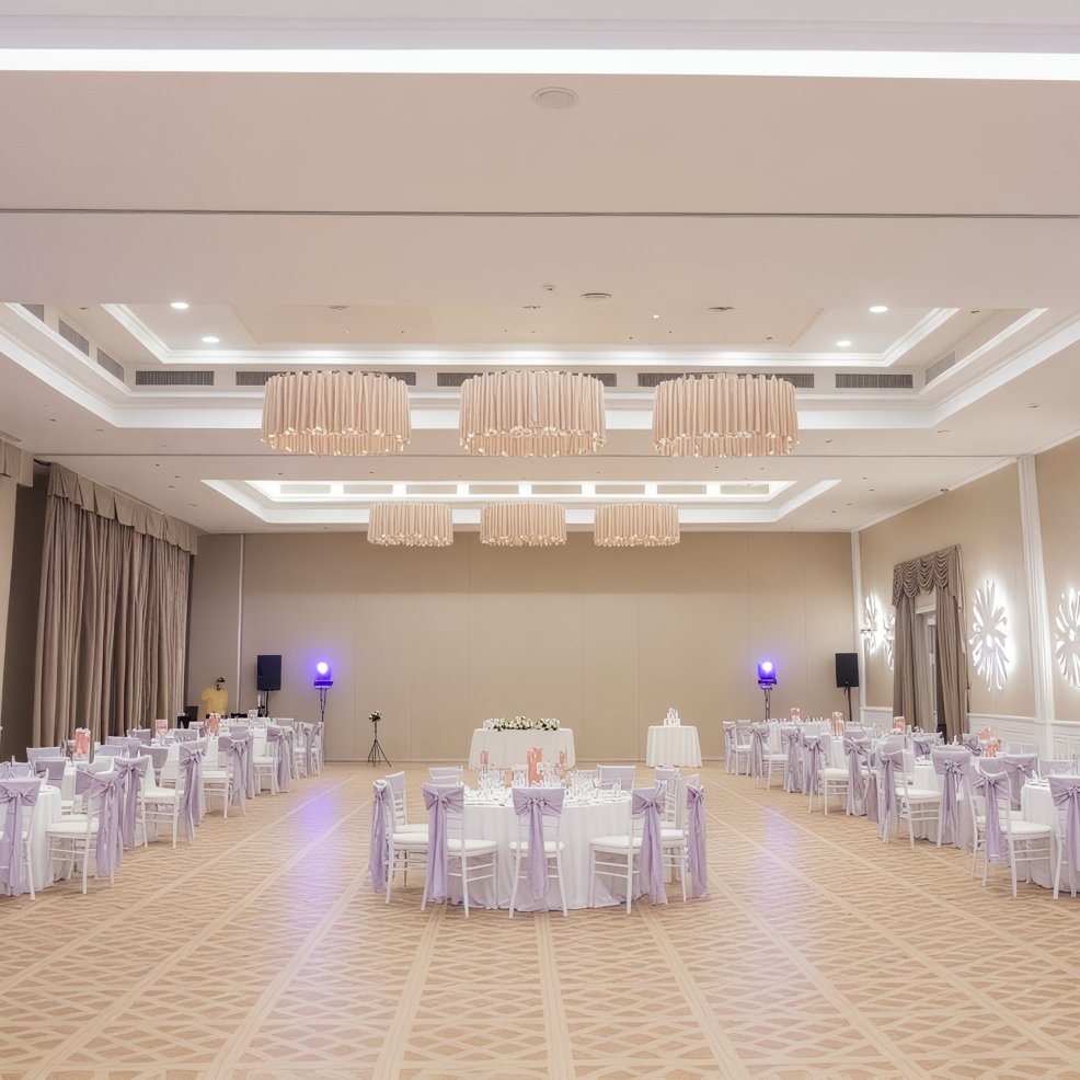 Elegant banquet hall with round tables arranged for a destination wedding, highlighted by modern lighting.