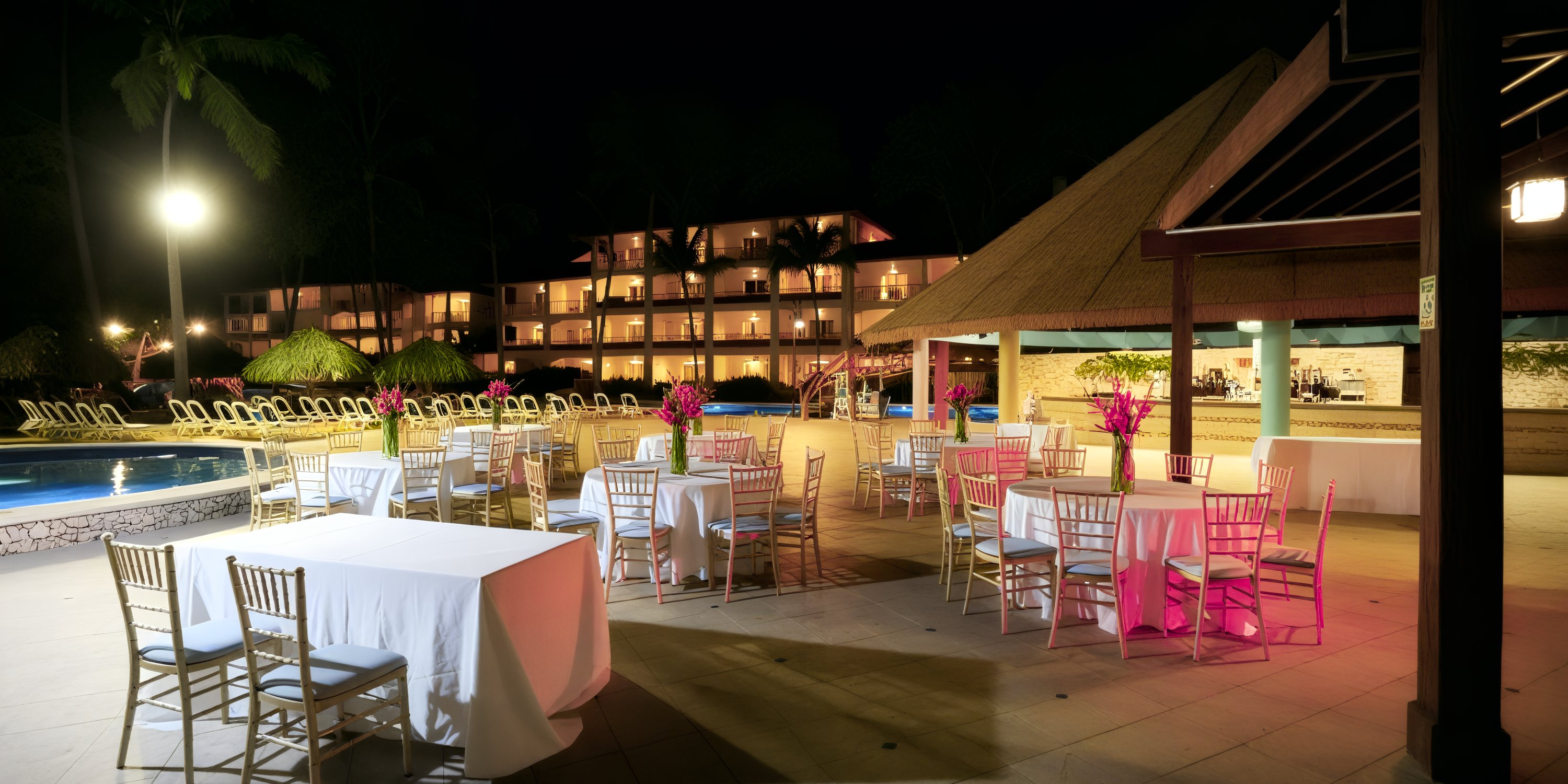 Elegant poolside dining, an ideal setting for a destination wedding at Majestic Colonial by night.