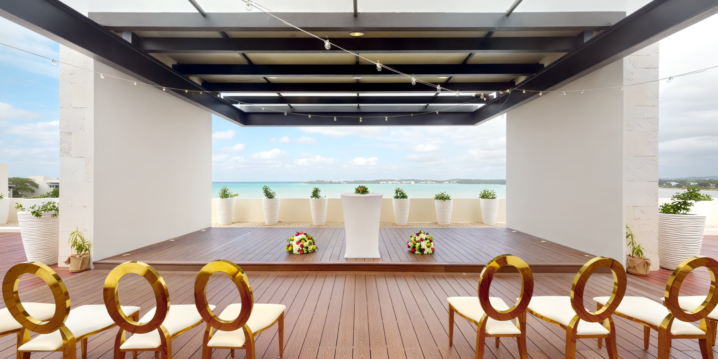 Royalton Negril offers a breathtaking destination wedding setup on their deck, featuring an ocean view with chairs elegantly arranged to face the altar.