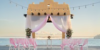 Destination wedding at Hotel Riu Santa Fe with pink and white decor, sea views, and a cruise ship nearby.