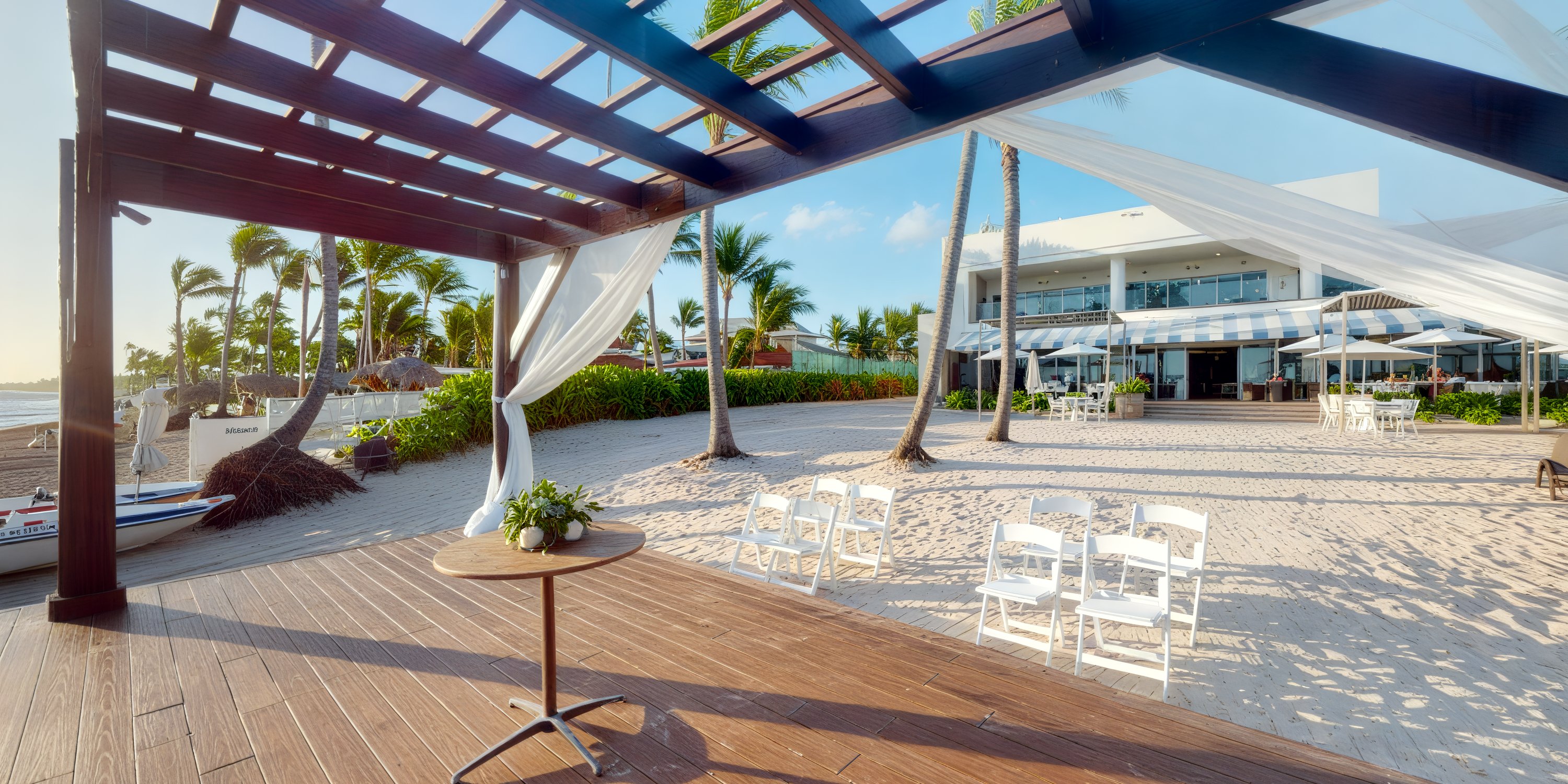 Destination wedding venue on the beach with white chairs, a pergola, and a table set on the sand.