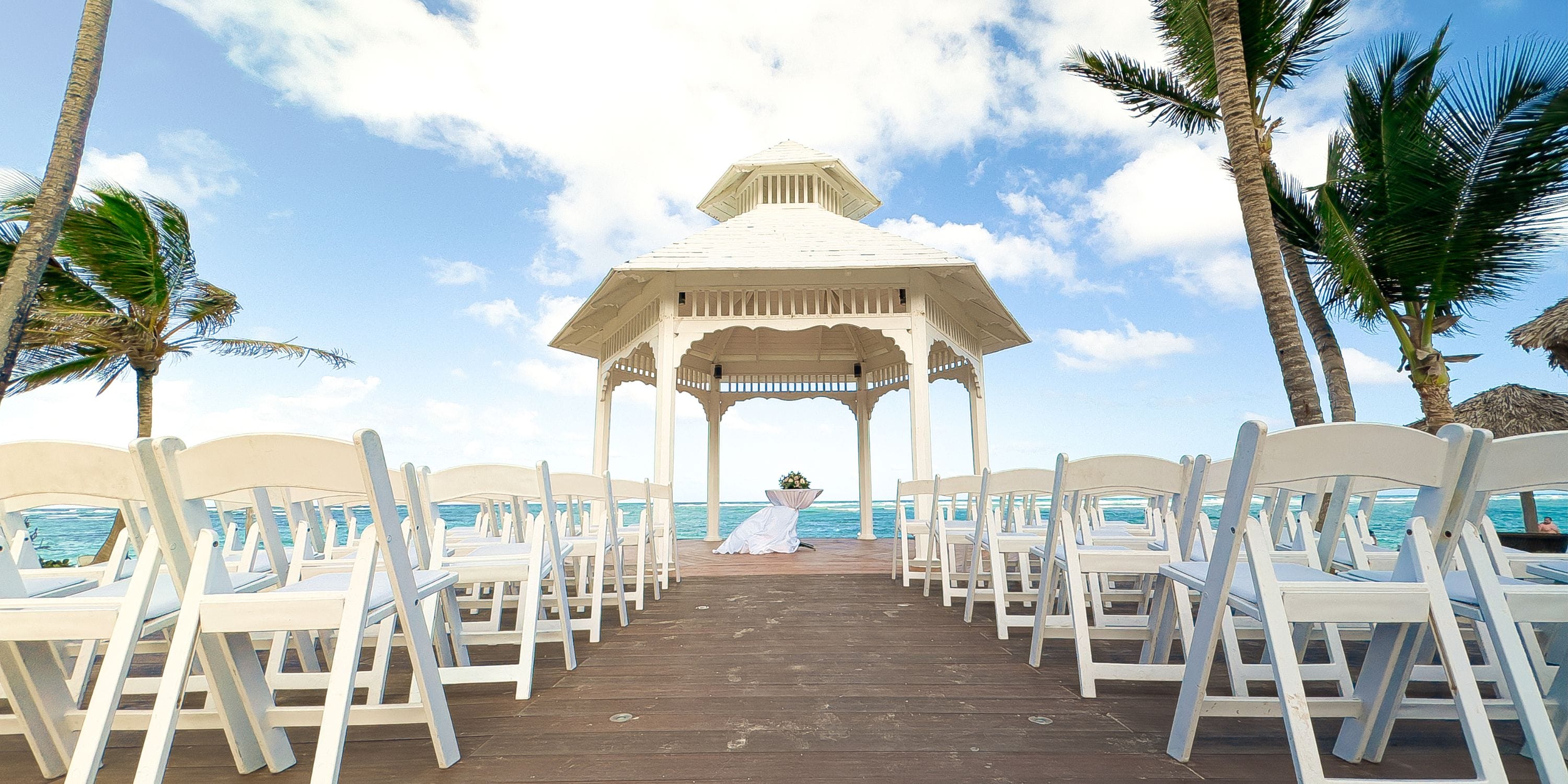 Destination wedding setup at Royalton Bavaro beach with white gazebo and chairs arranged on the sand.