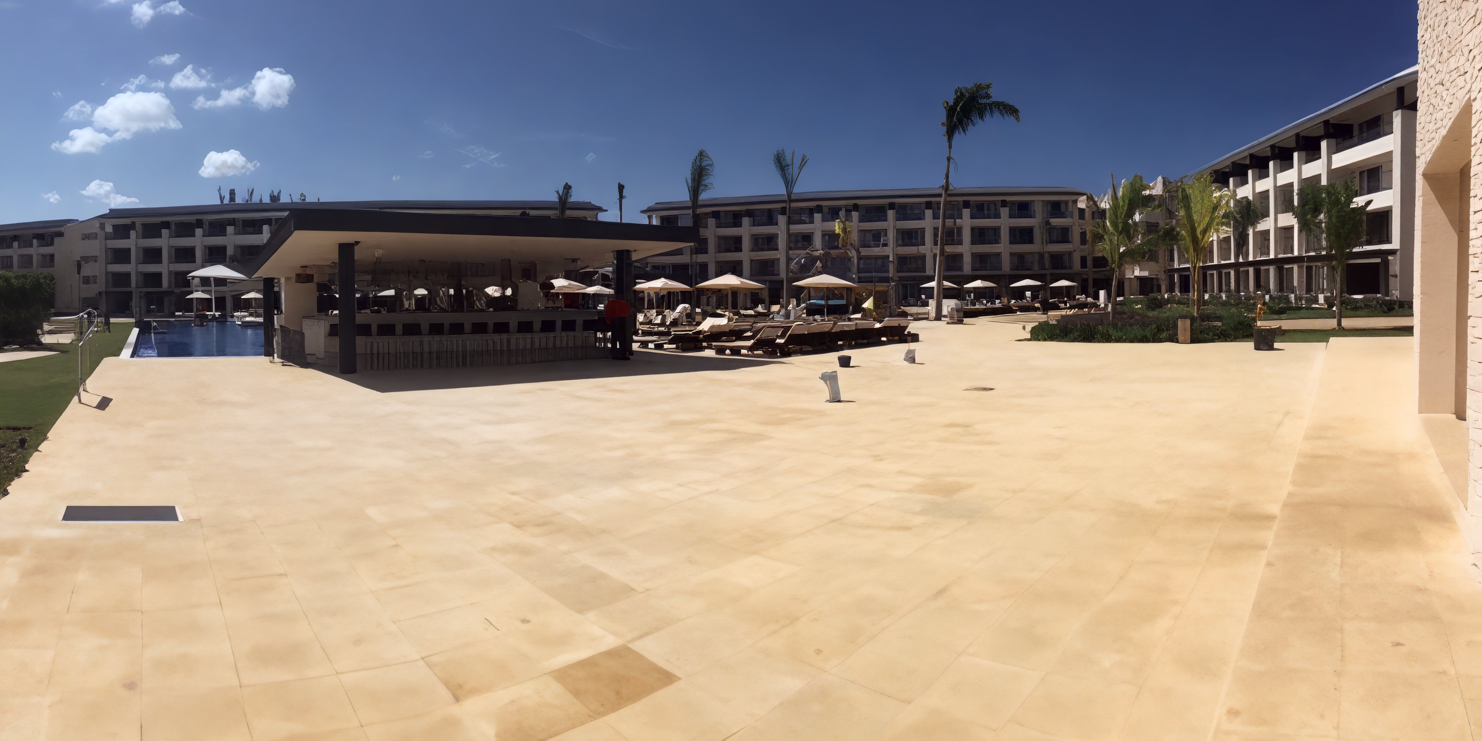 Elegant Royalton Negril courtyard, ideal for destination weddings, with pool bar, lounge chairs, and palms.