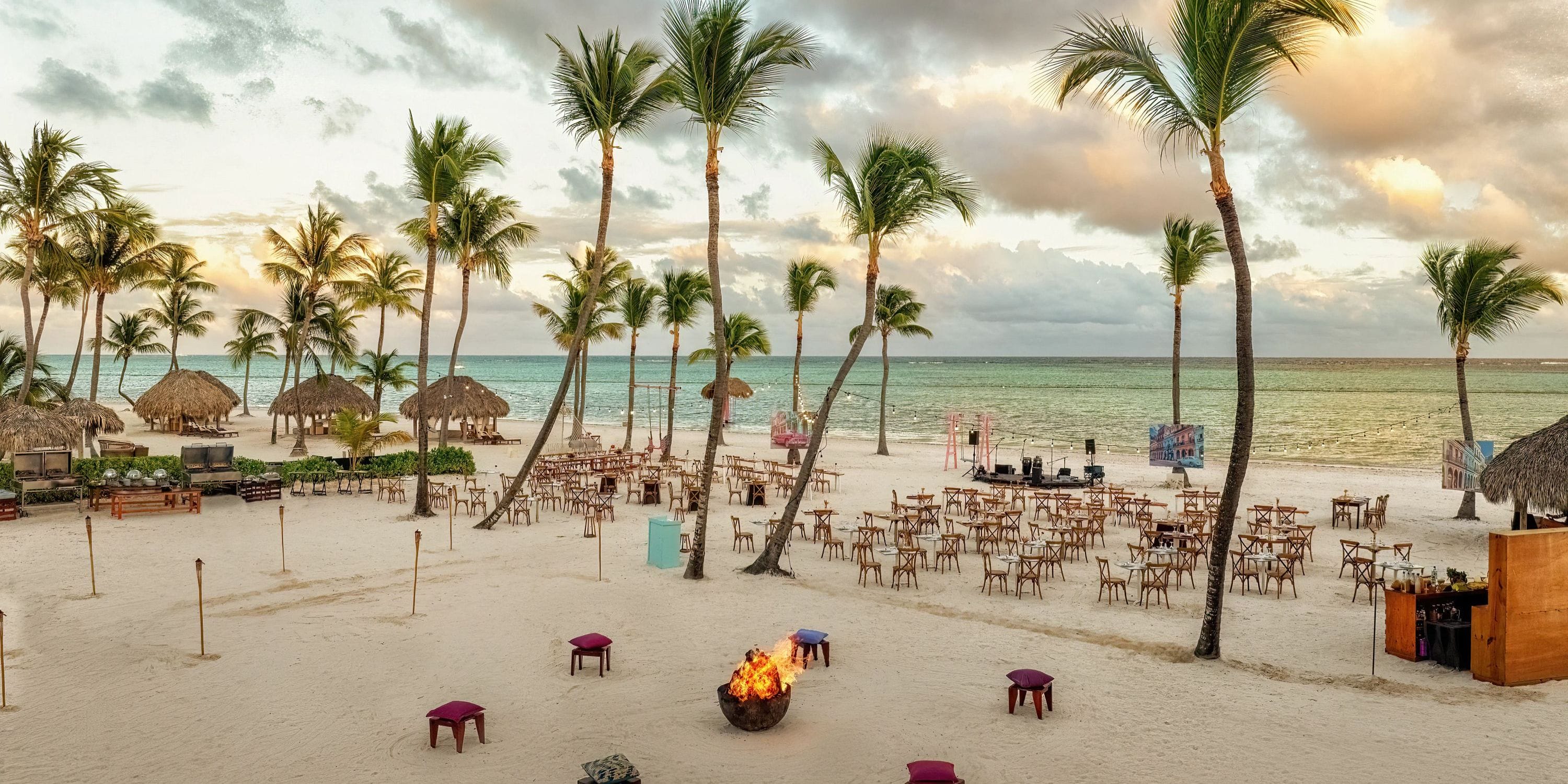 Wedding tables and chairs arranged on the sandy beach at Secrets Cap Cana for a destination wedding.