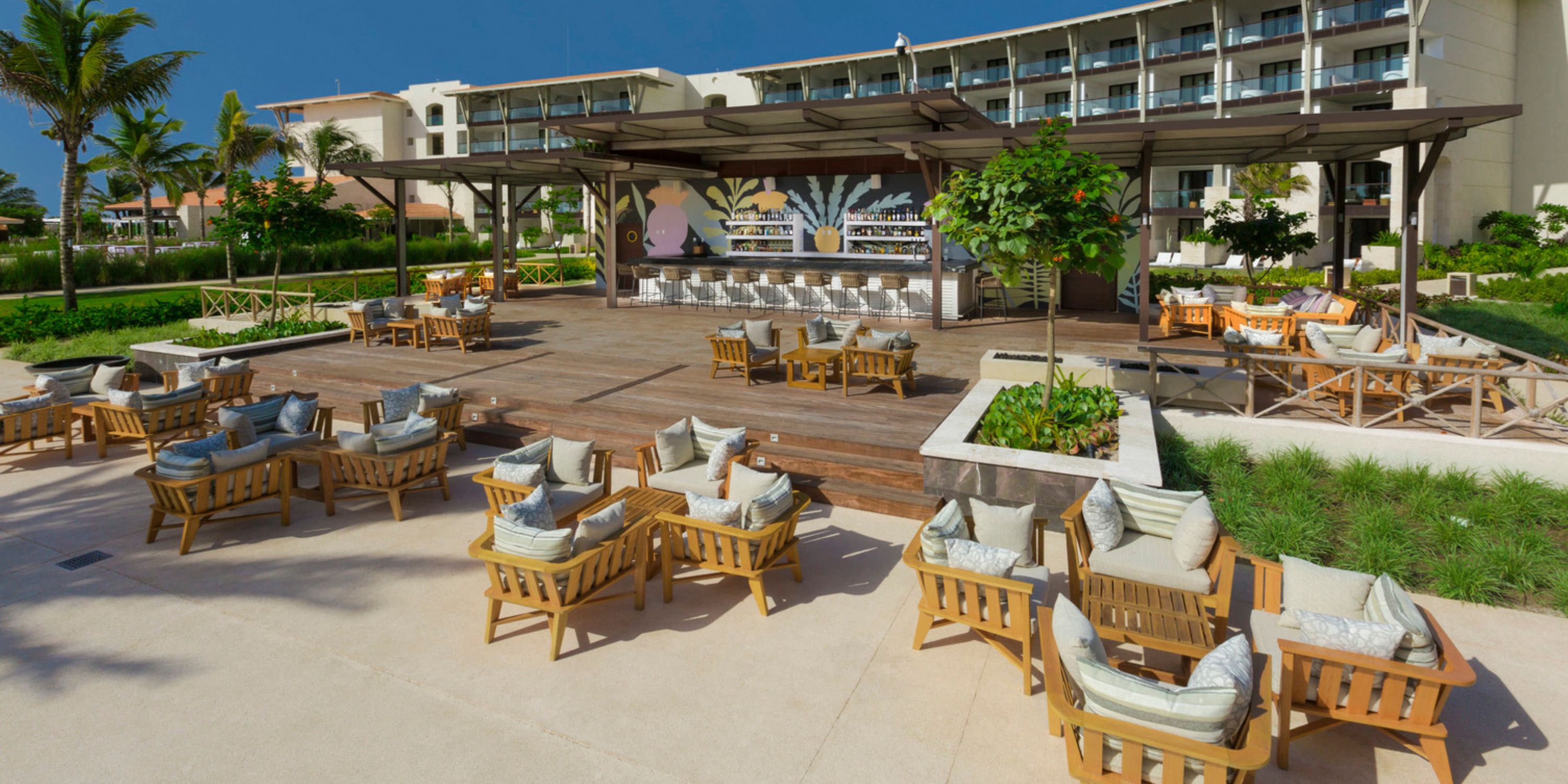 Outdoor bar with wooden seating and lush greenery, ideal for a destination wedding at UNICO 20&deg;87&deg;.