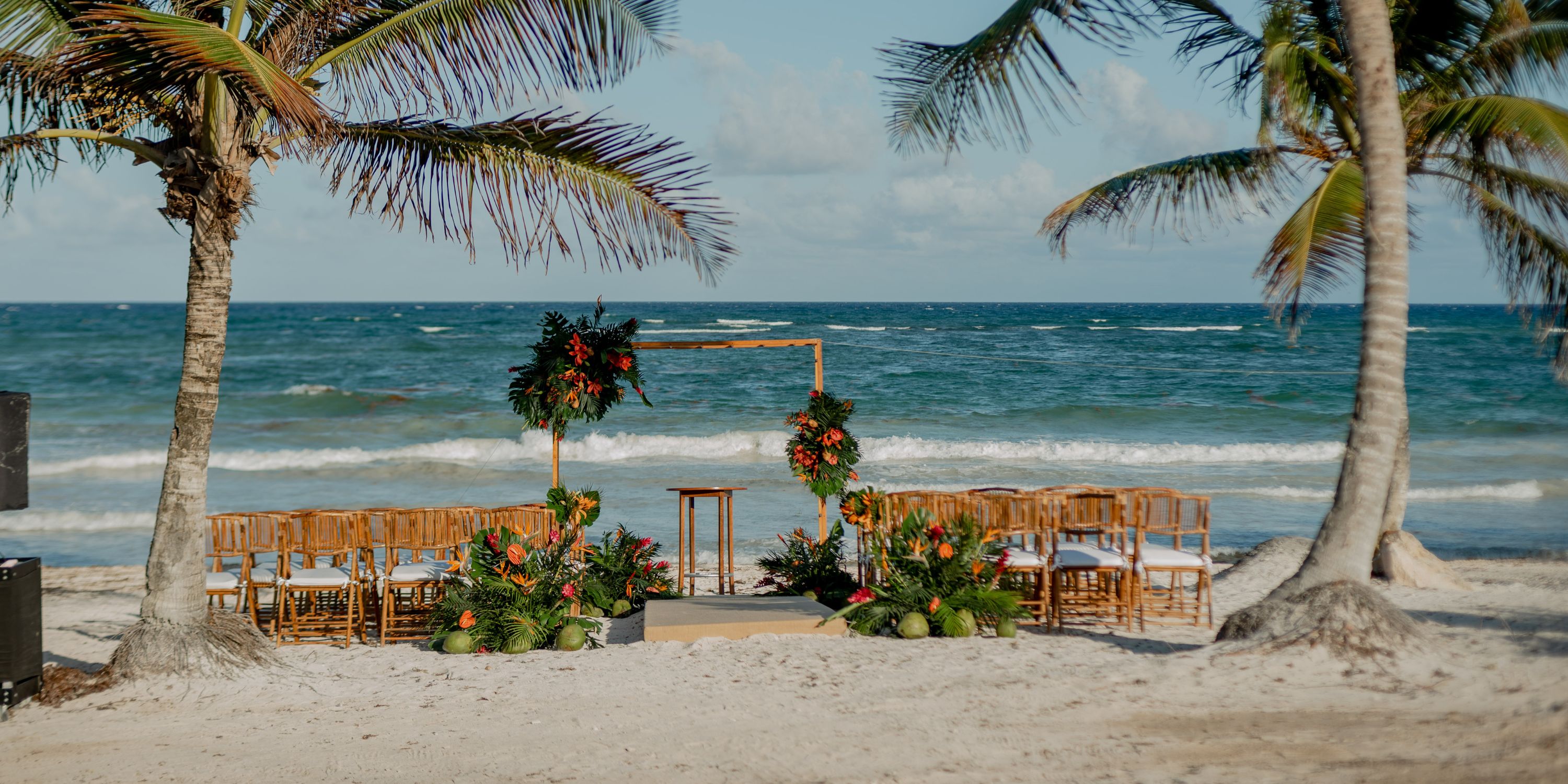 Destination wedding setup on the beach at UNICO 20&deg;87&deg; Riviera Maya with chairs, flowers, and an arch.